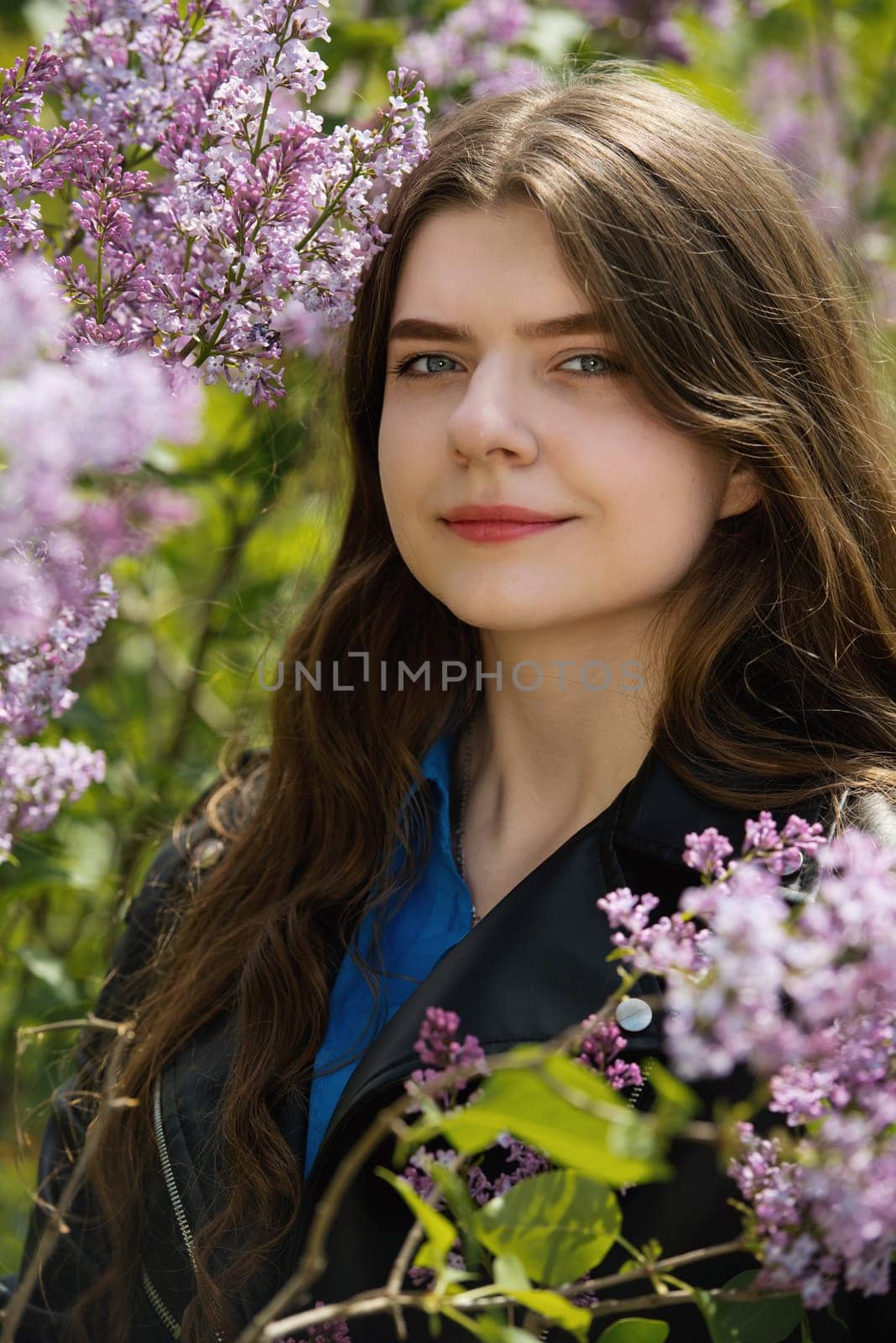 Portrait of a beautiful young woman surrounded by lilac flowers. by leonik