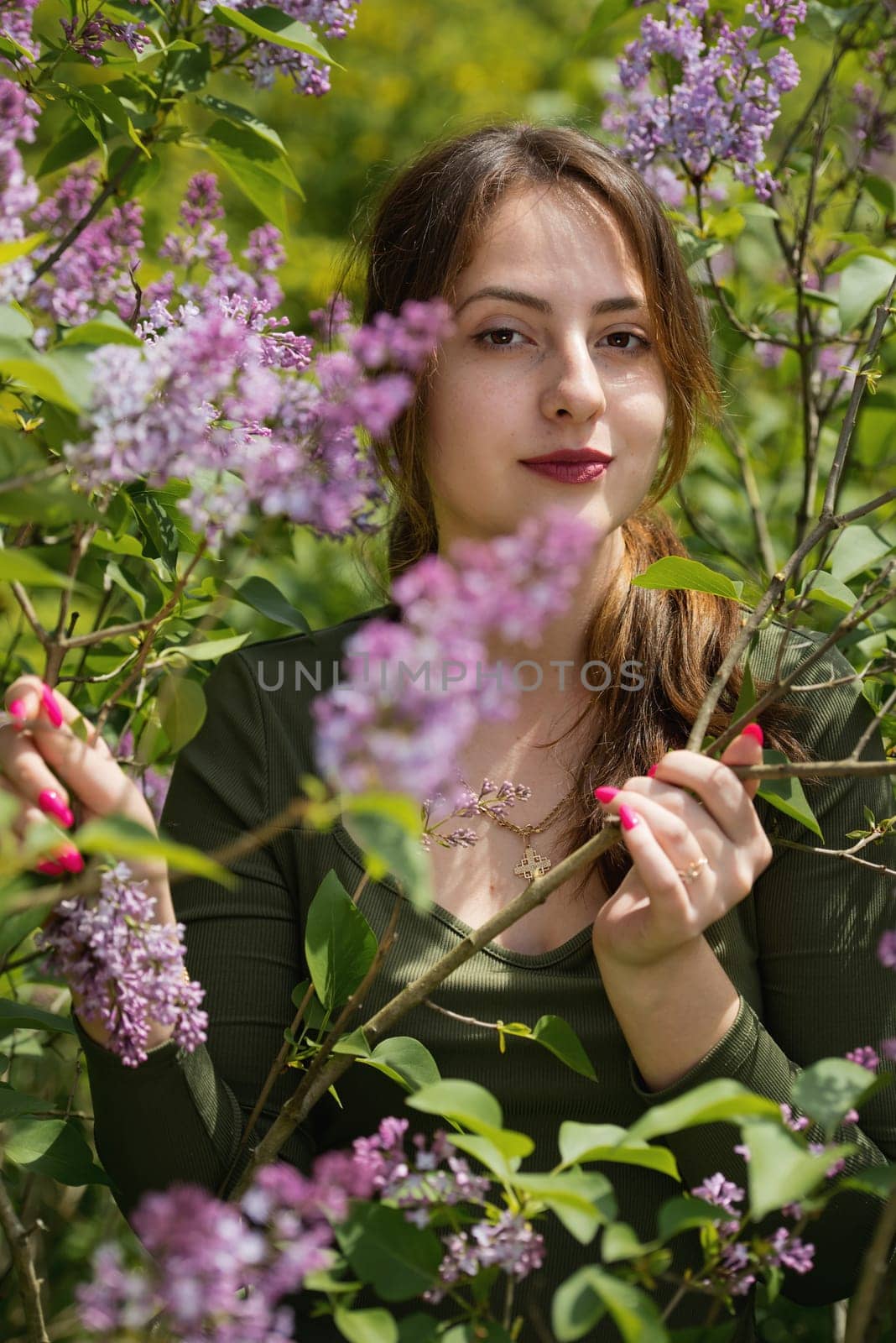 Portrait of a beautiful young woman surrounded by lilac flowers. by leonik