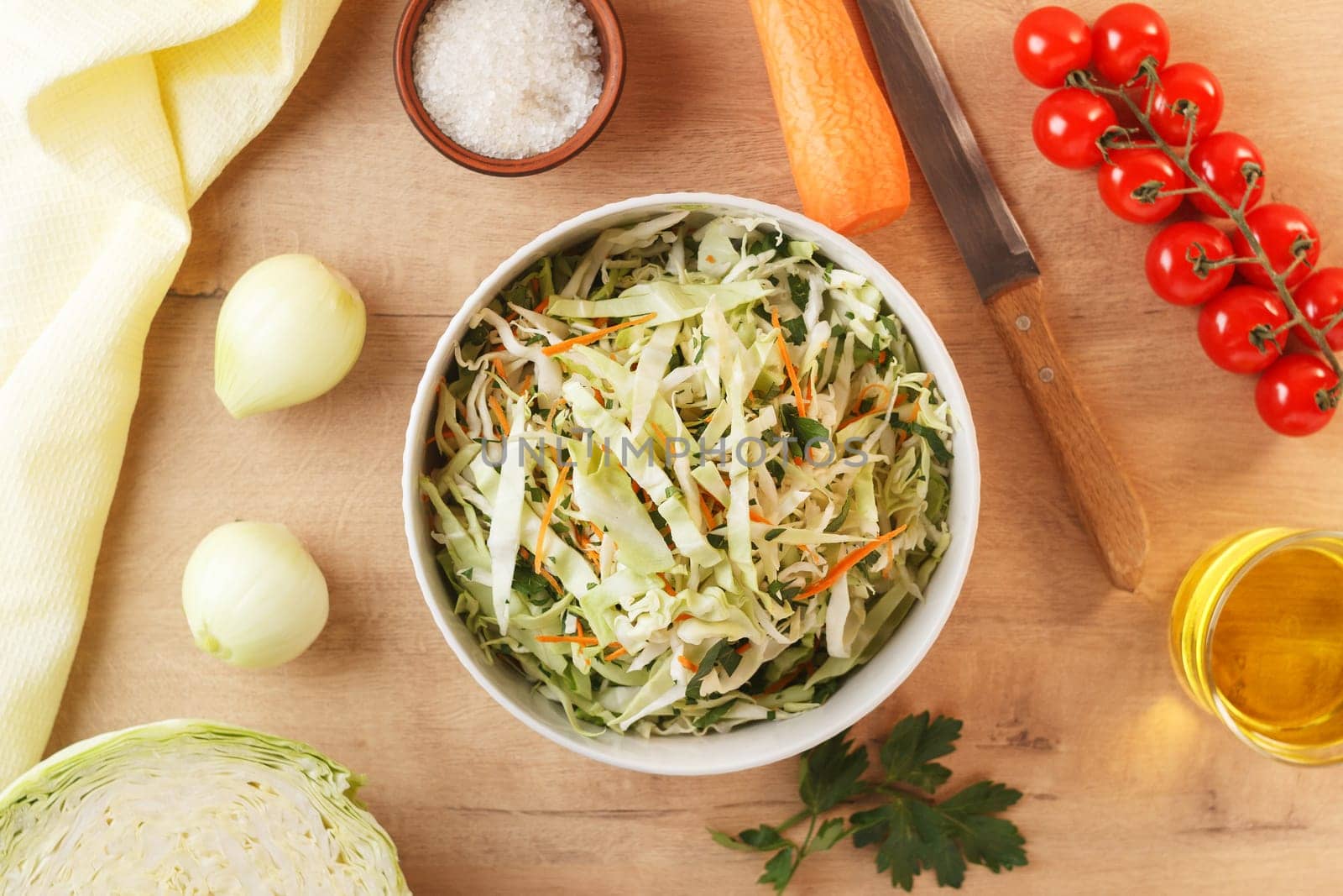 healthy vegan bowl of vegetable salad for lunch. Cabbage, carrots, parsley, onion, olive oil. View from above