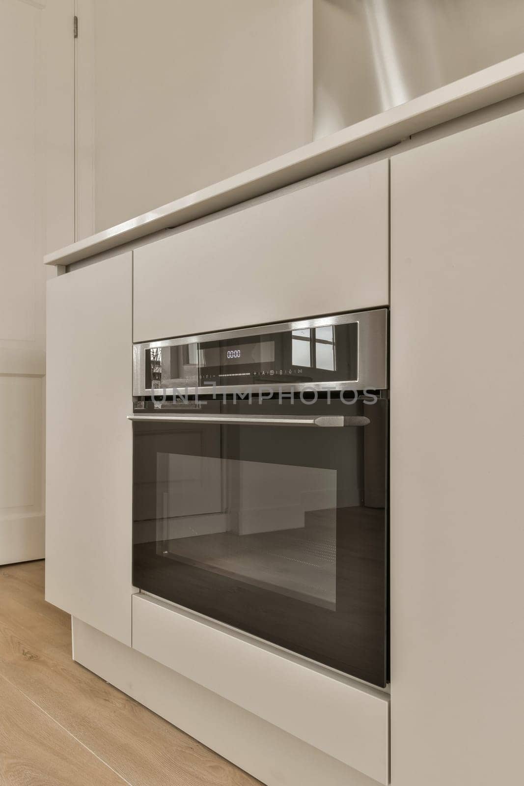 a kitchen with white cabinets and an oven in it by casamedia