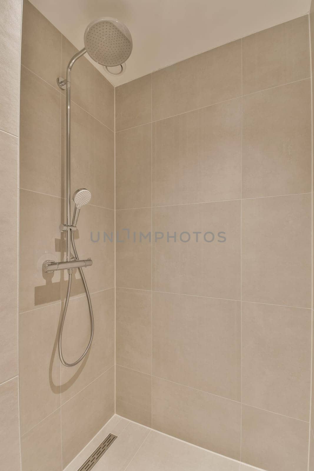 a shower with a shower head in a bathroom by casamedia