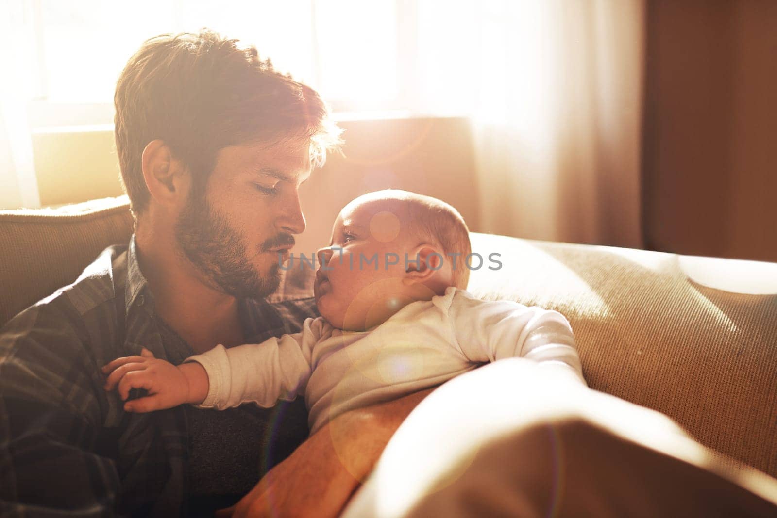 Shhh...time to sleep now. a young father and his baby boy in the living room. by YuriArcurs