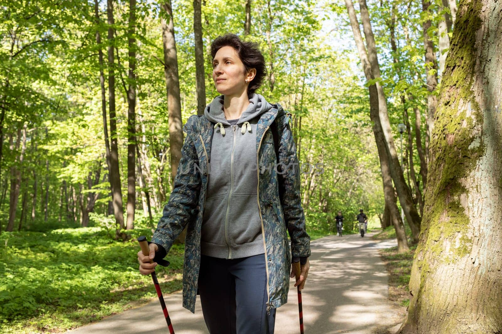 Portrait Beautiful 36 yo Woman Trekking With Sticks, Happy Caucasian 36 yo Hiking Female, Nordic Walking With Sticks, Cross-country Running. Horizontal Plane High quality photo