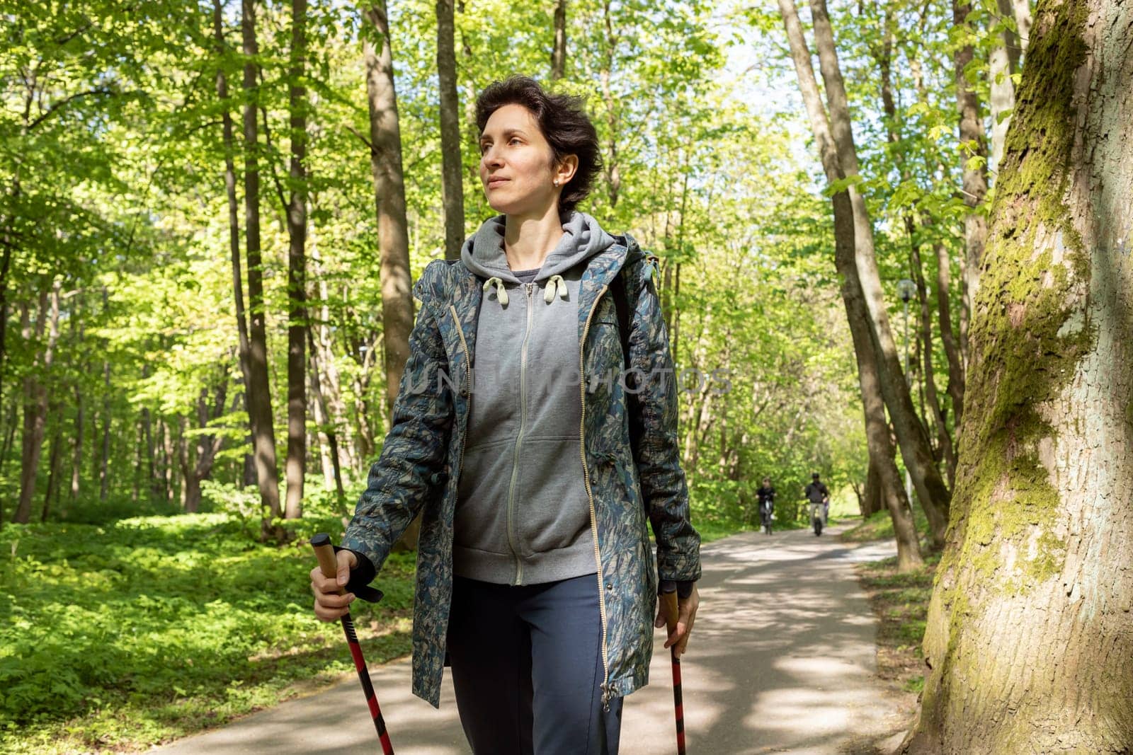 Portrait Beautiful 36 yo Woman Trekking With Sticks, Happy Caucasian 36 yo Hiking Female, Nordic Walking With Sticks, Cross-country Running. Horizontal Plane High quality photo