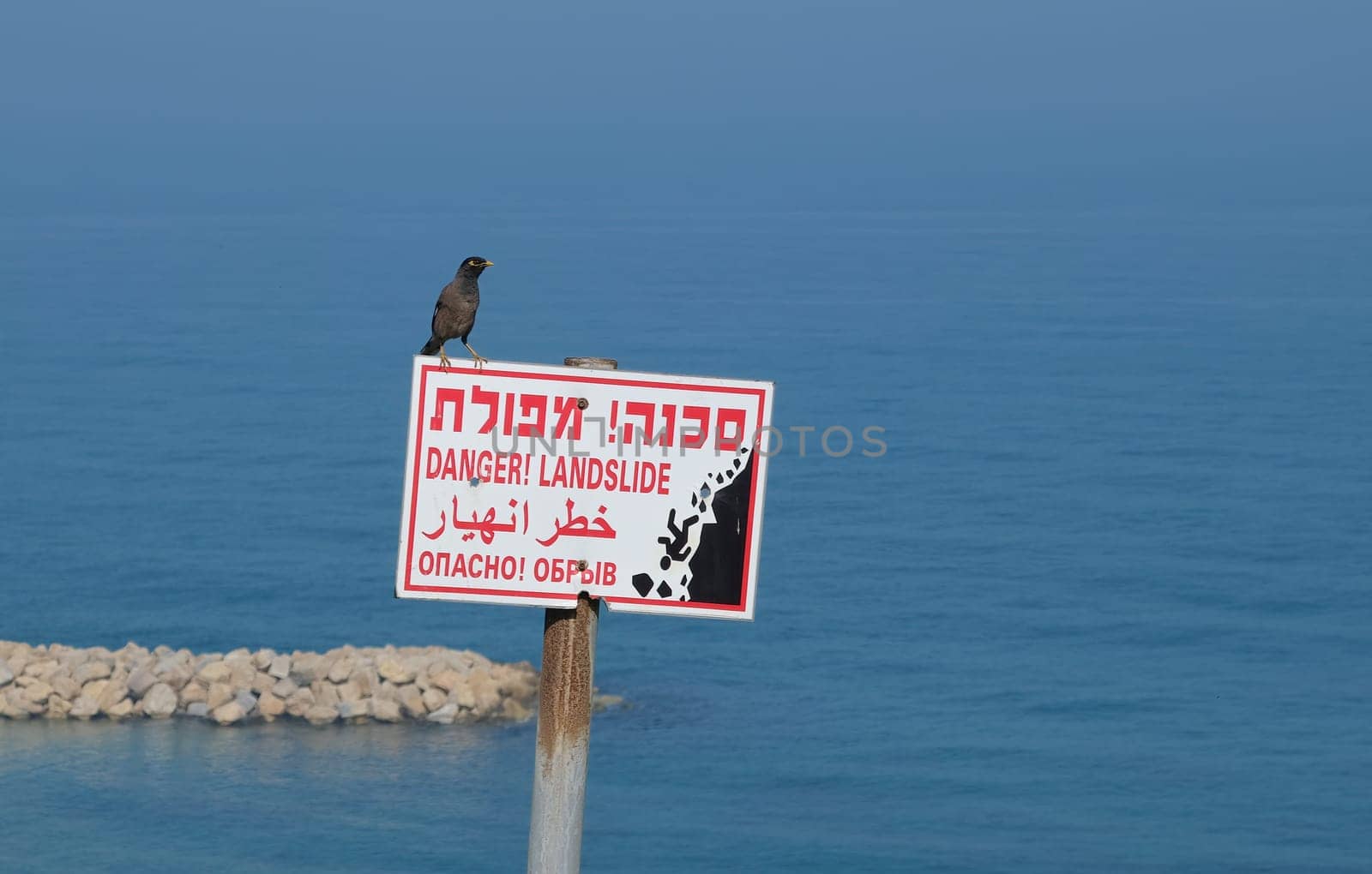 Danger. Landslide sign in Netanya, Israel sign that warns about the danger ahead of dubbed the Hebrew inscriptions