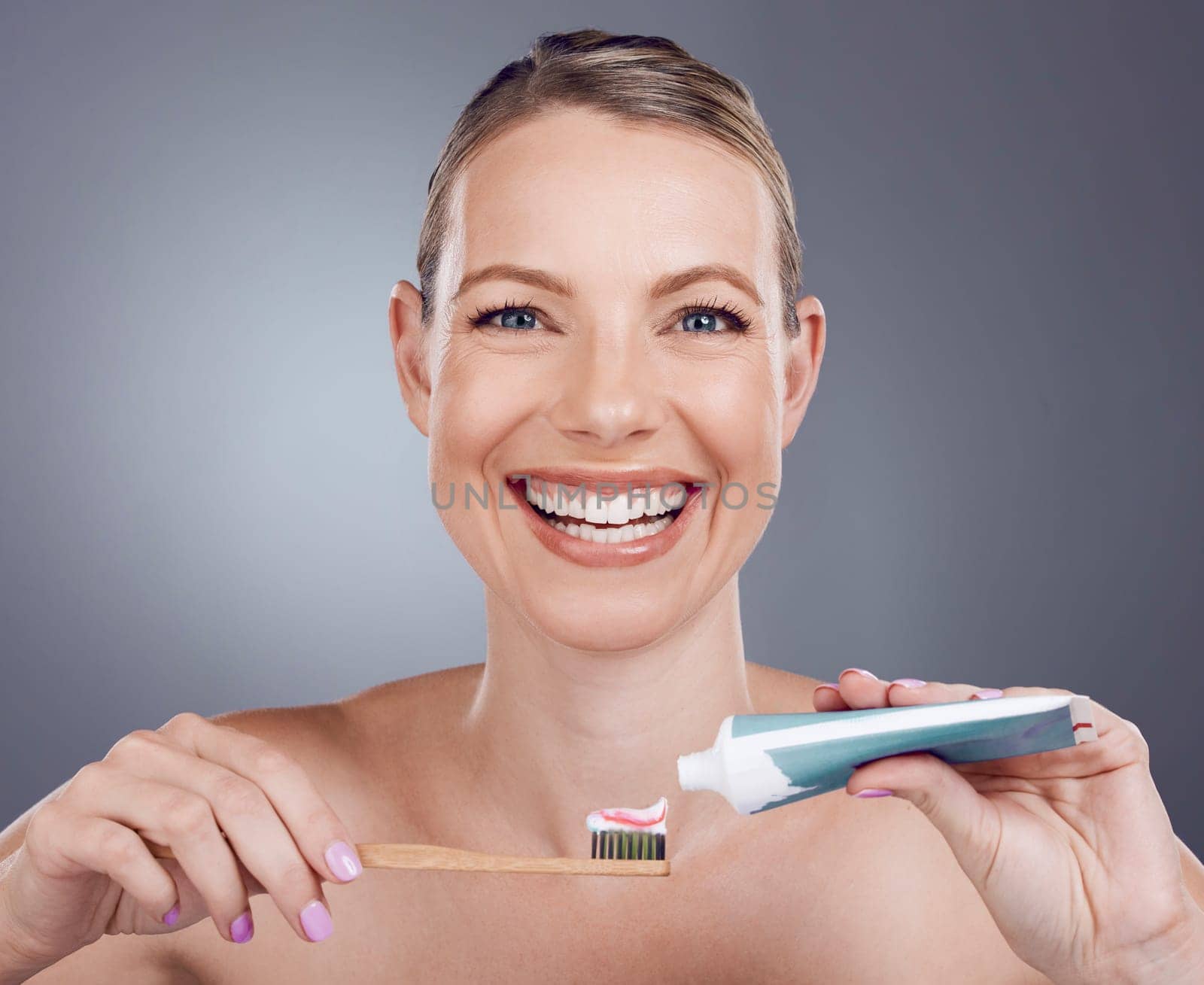Toothpaste, bamboo toothbrush and portrait of woman in dental wellness, healthy smile or eco cosmetics. Female model cleaning teeth with wooden brush, mature face or happy beauty on studio background.