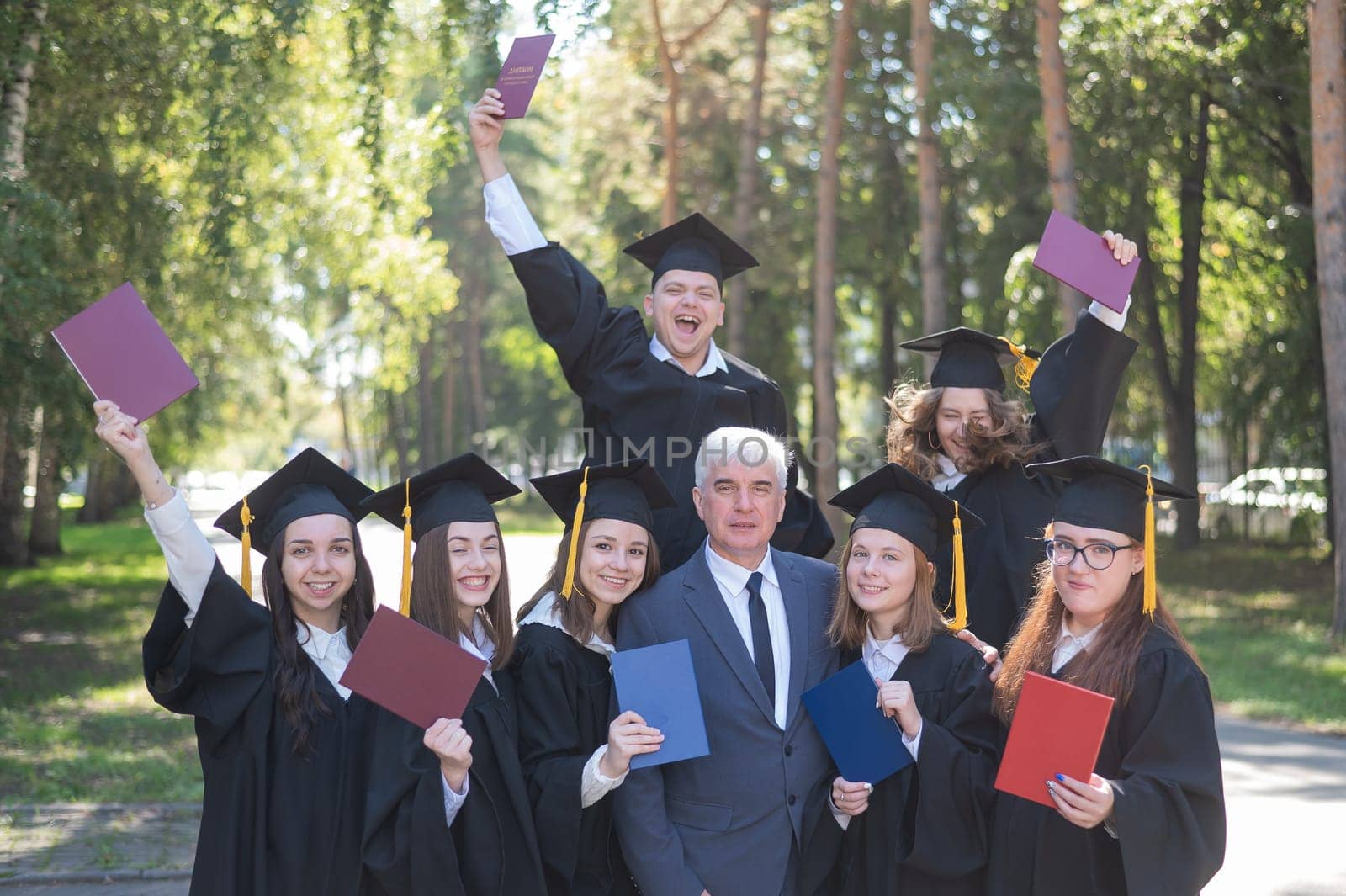University professor and seven graduates rejoice at graduation. by mrwed54