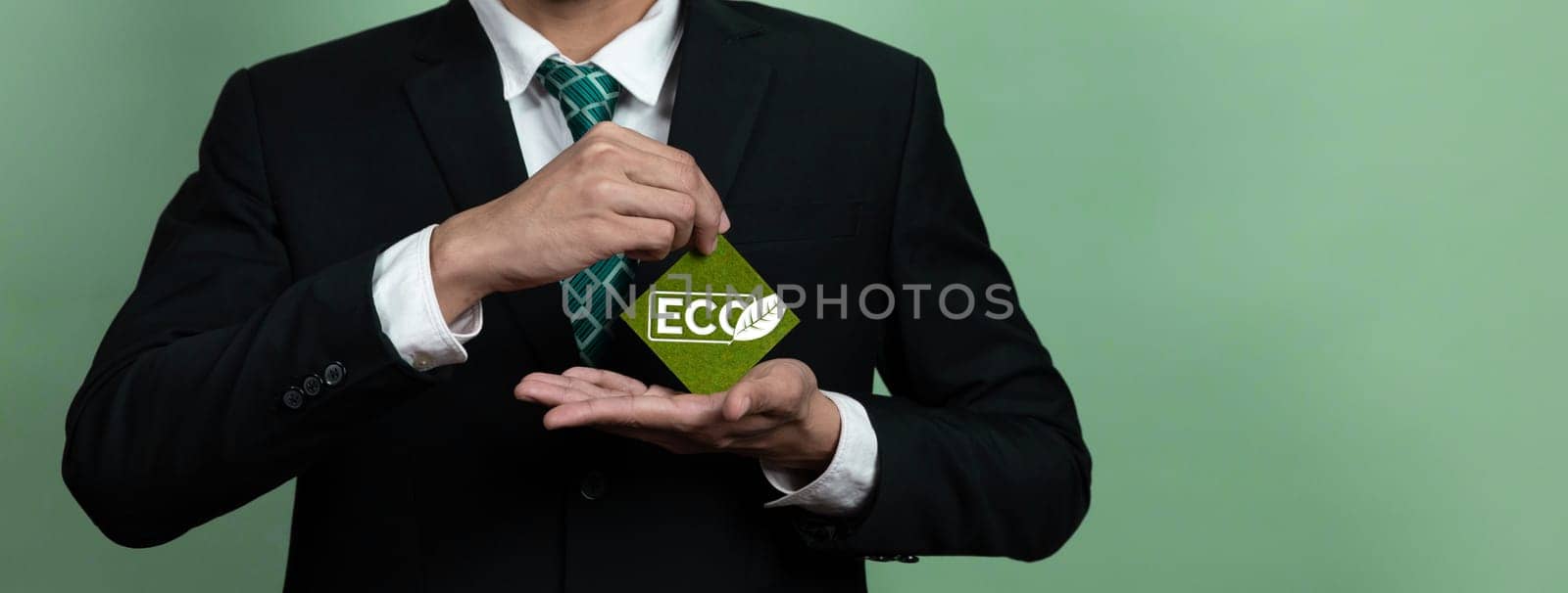 Eco-friendly corporate promoting sustainable and green business concept with businessman hold ECO symbol paper as environmental protection commitment using clean energy with zero CO2 emission. Alter