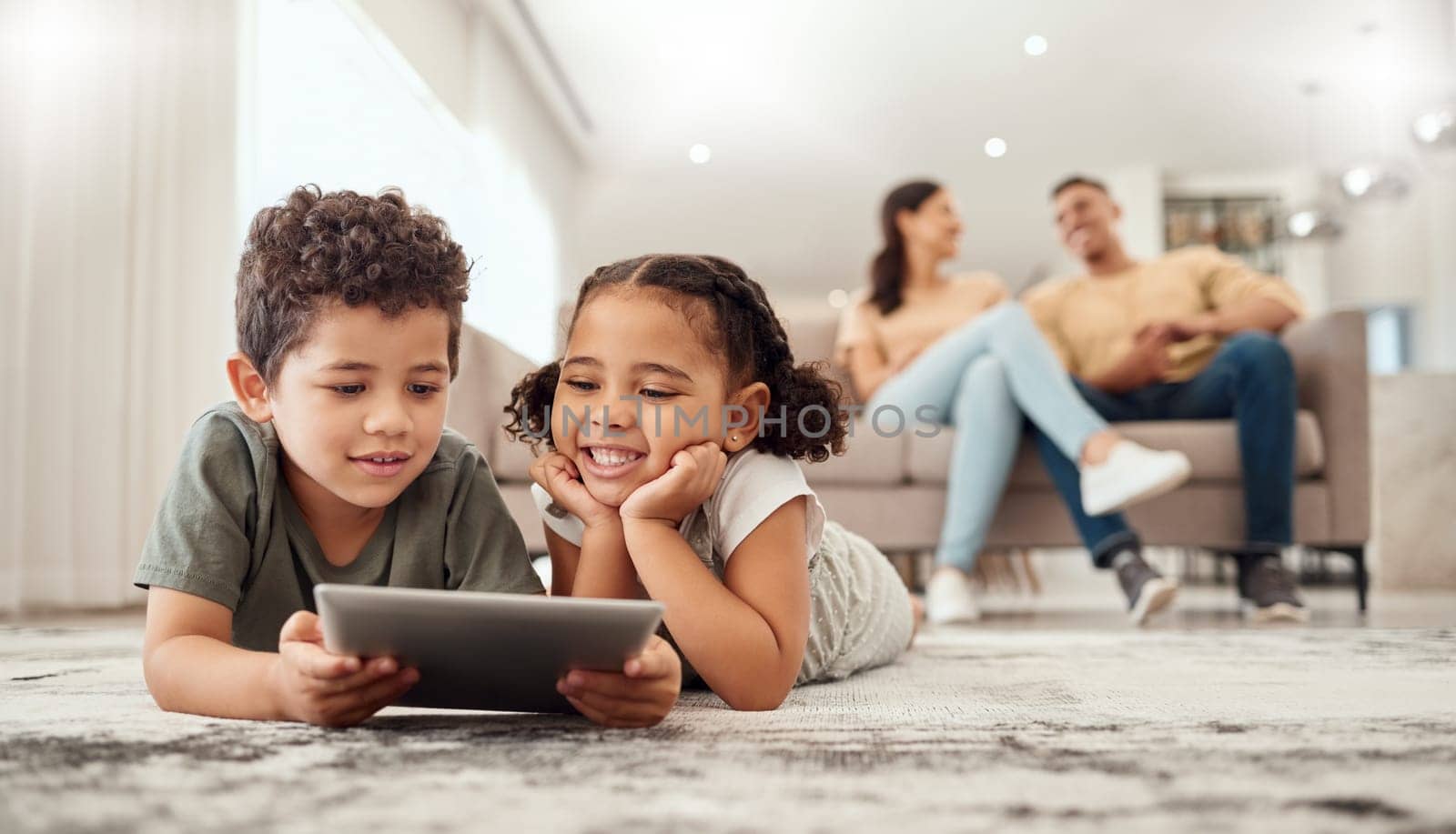 Learning, tablet and children streaming a video on technology on the living room floor of their house. Education, happiness and movies on technology for kids with parents on the sofa in their home.