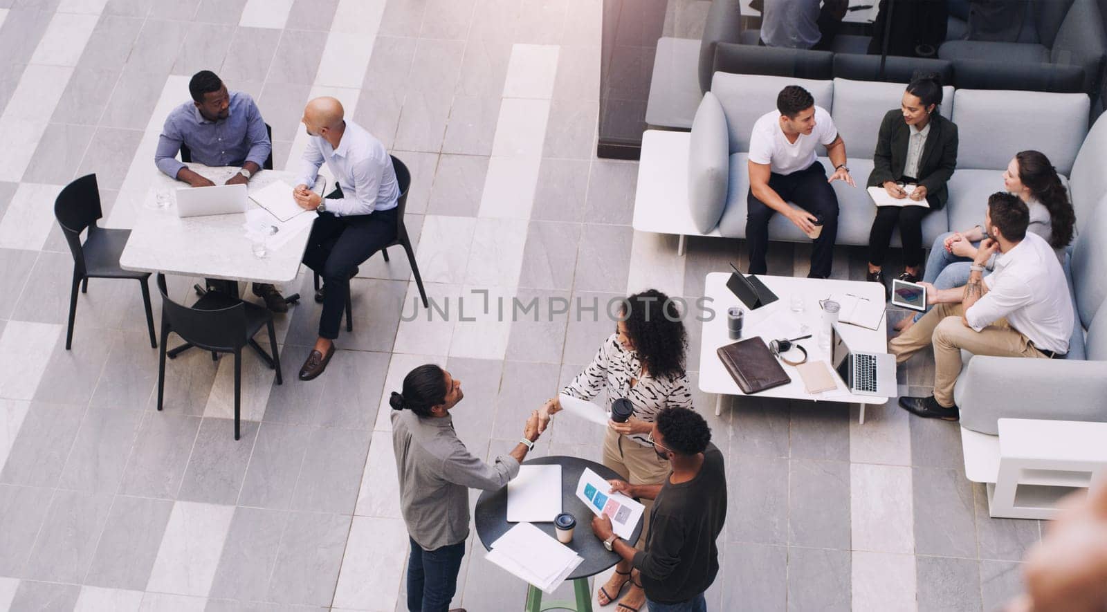 Top view, businesspeople talking and meeting at a conference at their office space. Diversity at work, communication or collaboration and networking or event planning have a conversation together.