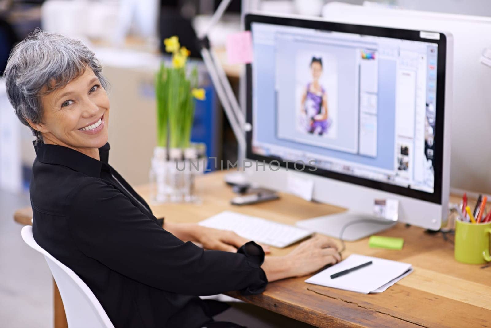 Senior woman at desk, computer screen and smile in portrait, editor at magazine and editing image with software for publication. Professional female with creativity and editorial career with design.