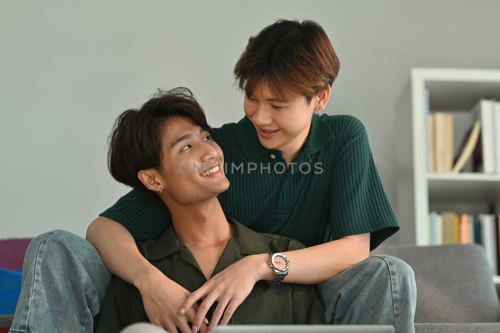 Affectionate moment of gay couple while embracing and looking to each other. LGBT, love and lifestyle relationship concept by prathanchorruangsak