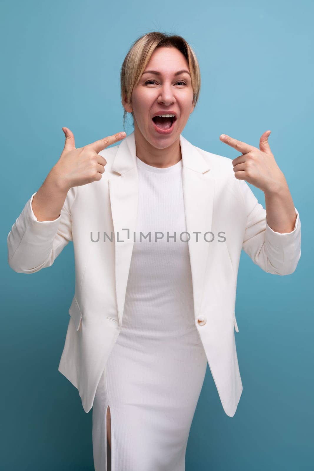 pretty young fair-haired business woman in a jacket and dress makes a speech.