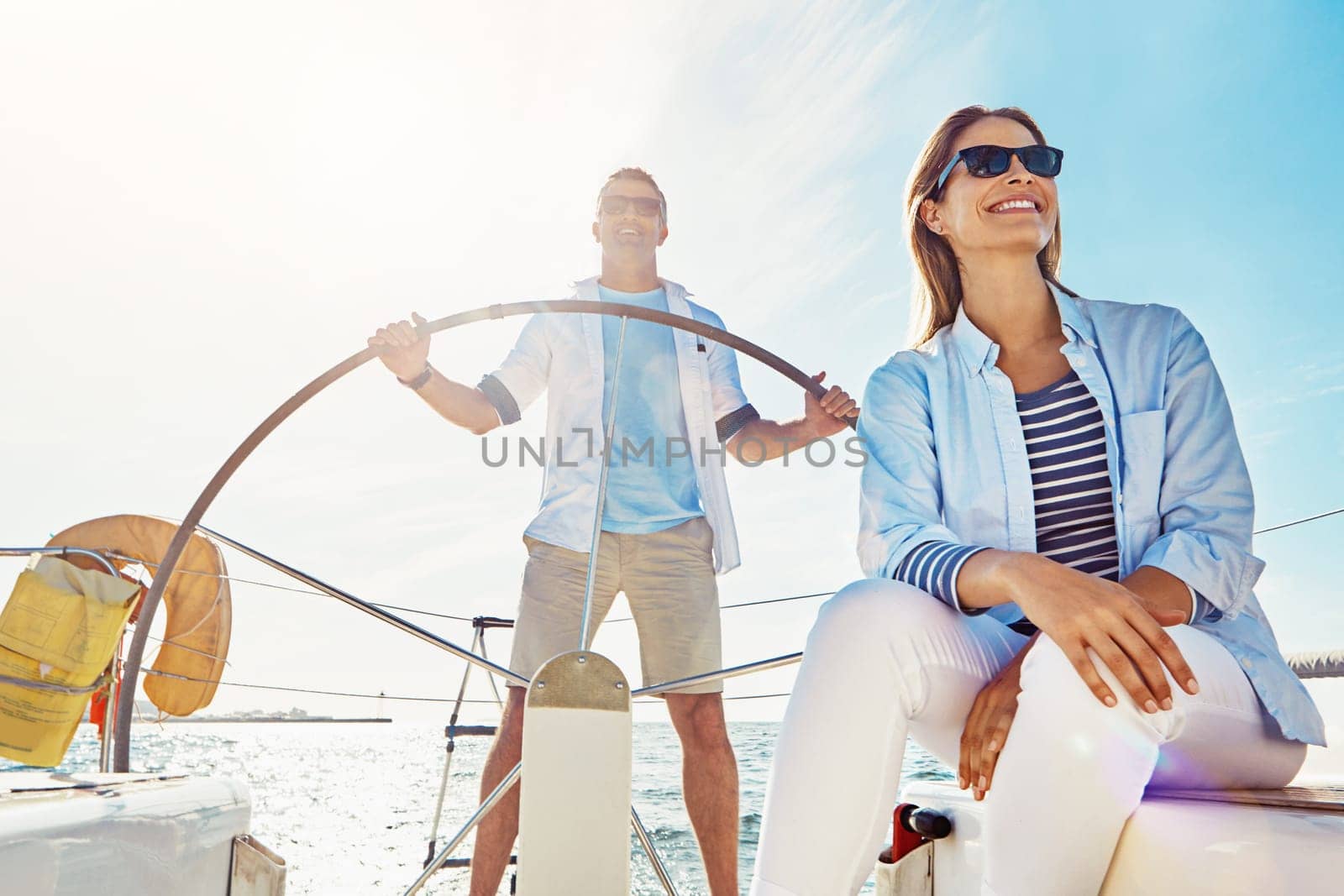 Holiday, boat and rich couple at sea with sunshine on a cruise for summer vacation with happiness. Yacht, luxury and travel for adventure with transportation for freedom in the outdoor with sun
