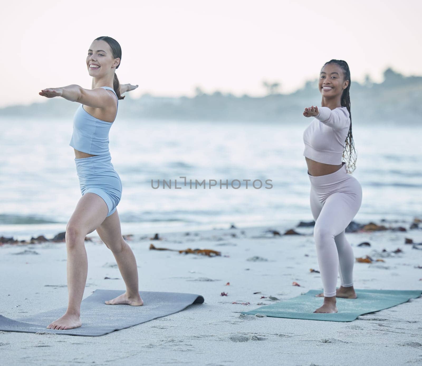 Friends, yoga and stretching on the beach for health, wellness and body fitness by the ocean. Seaside, sport and active women yogi with friendship for active, fit and peaceful workout or exercise by YuriArcurs