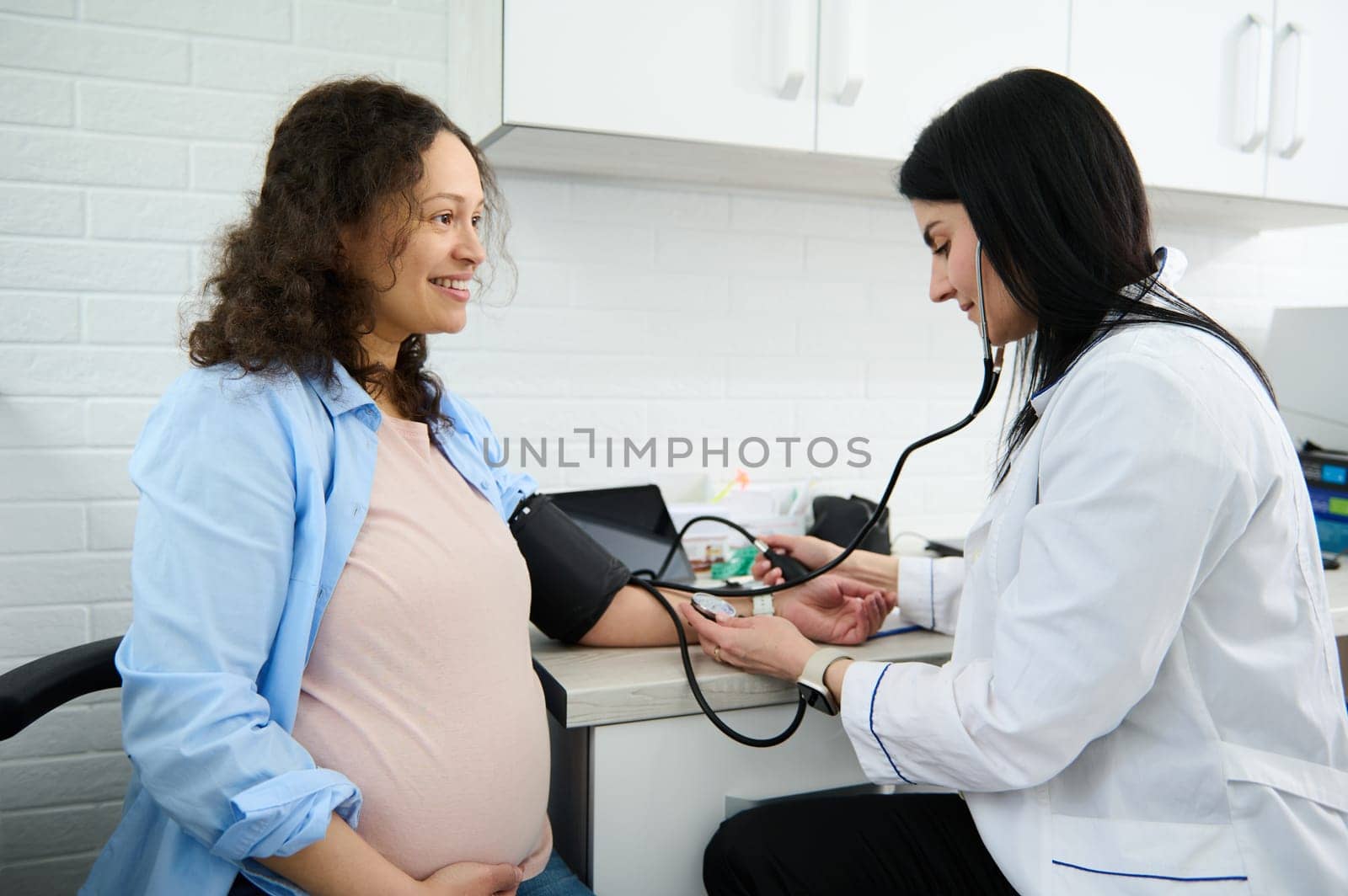 Pregnancy-induced hypertension. Prophylaxis of eclampsia. Obstetrician doctor measures blood pressure of pregnant woman by artgf
