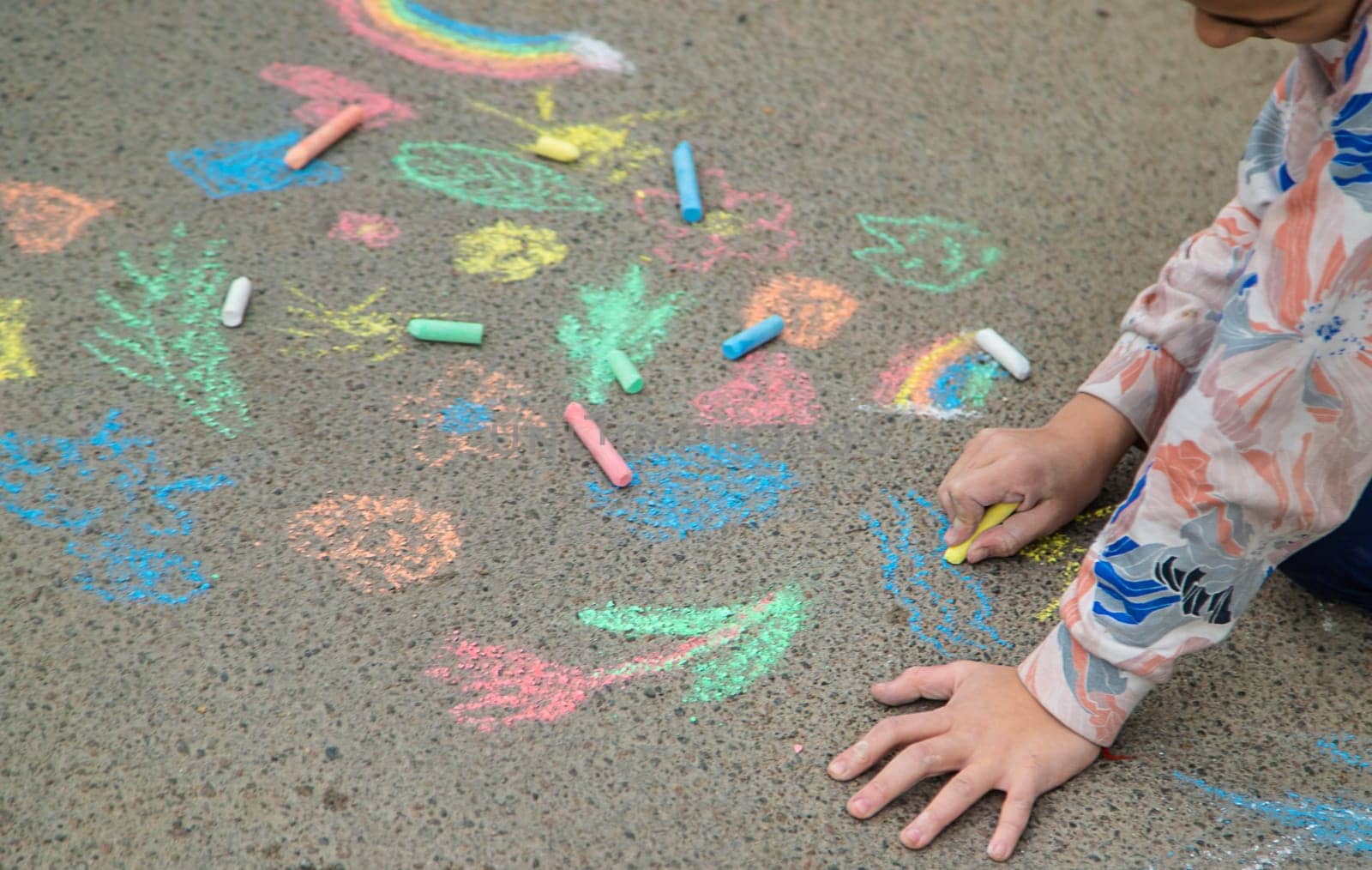 Children draw with chalk on the pavement. Selective focus. Kid.