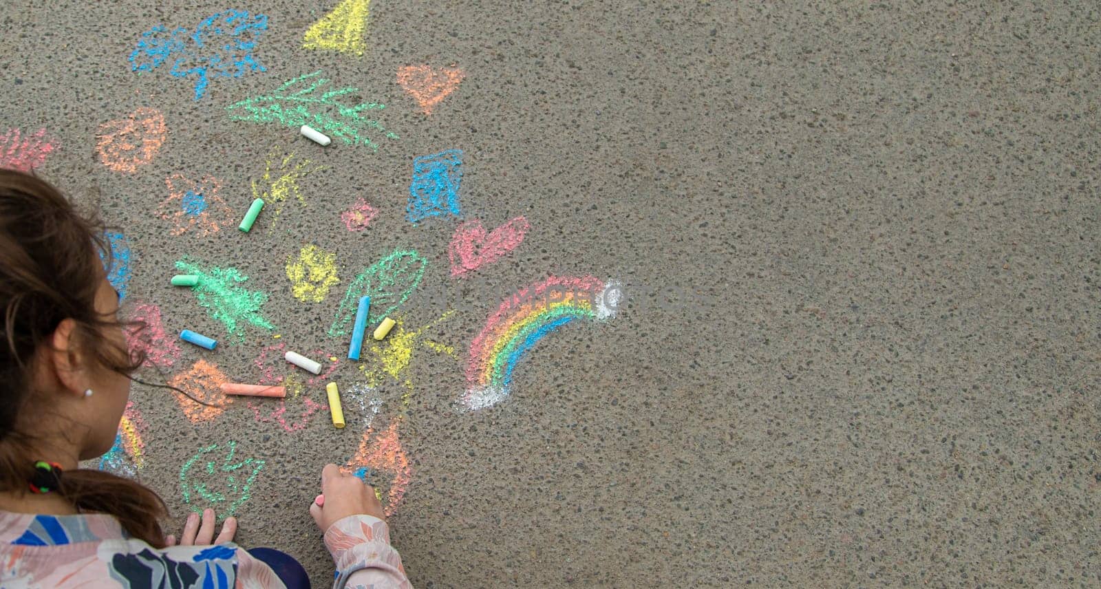 Children draw with chalk on the pavement. Selective focus. by yanadjana