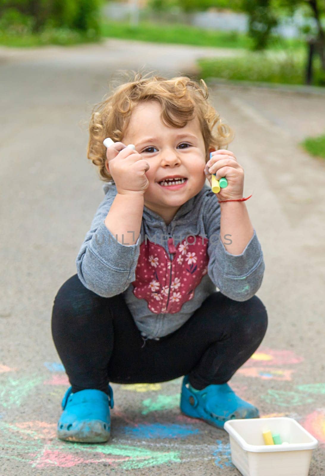 Children draw with chalk on the pavement. Selective focus. Kid.