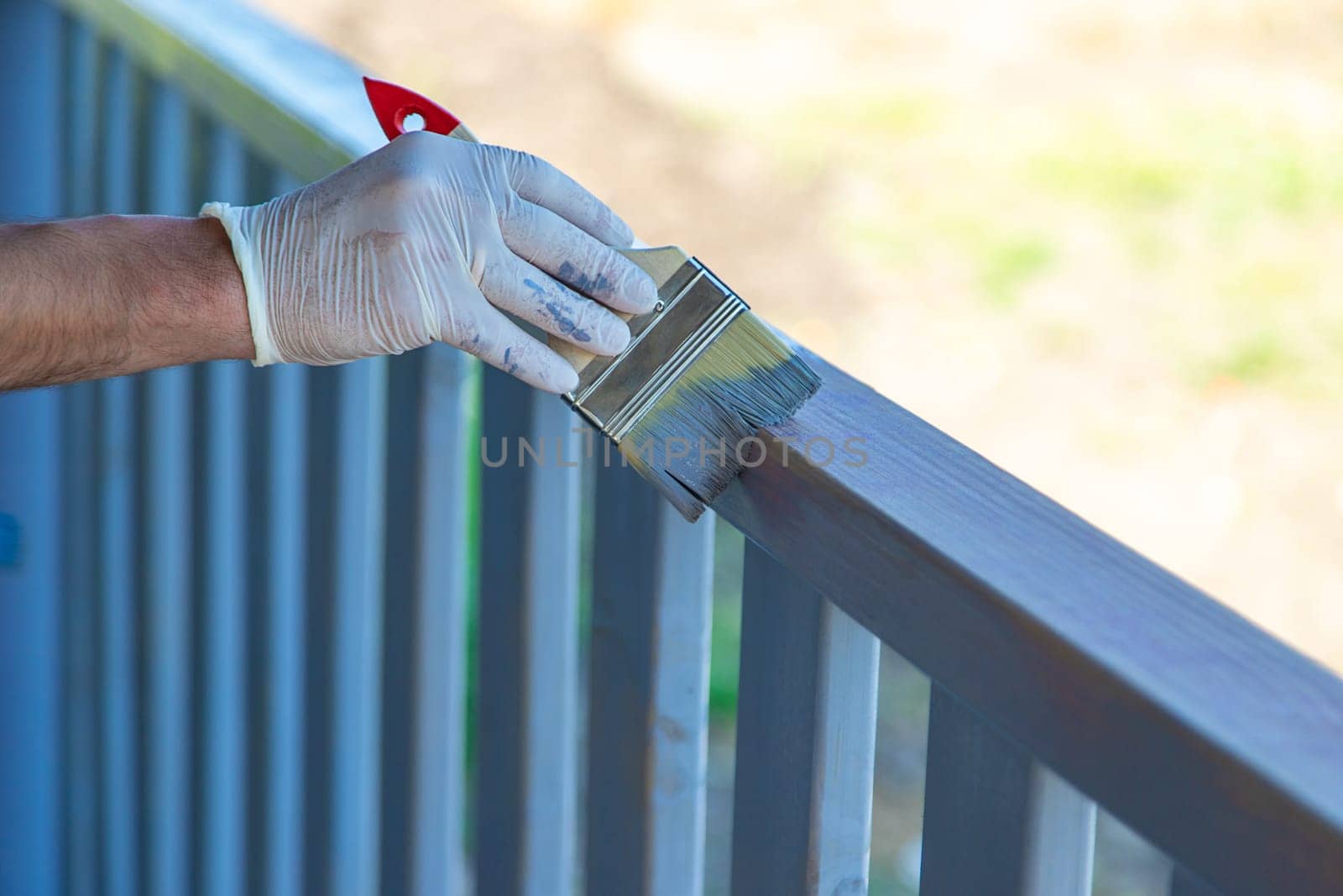 Painting a wooden board with a gray brush. Selective focus. by yanadjana