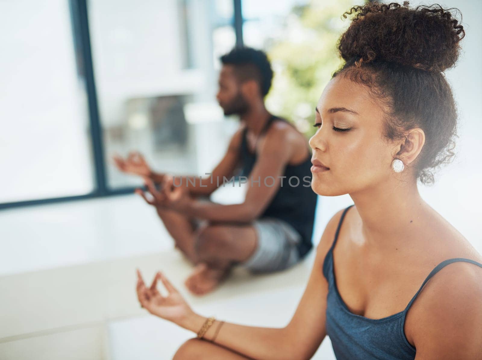 Get your yoga on. Shot of two people doing yoga together in a studio. by YuriArcurs