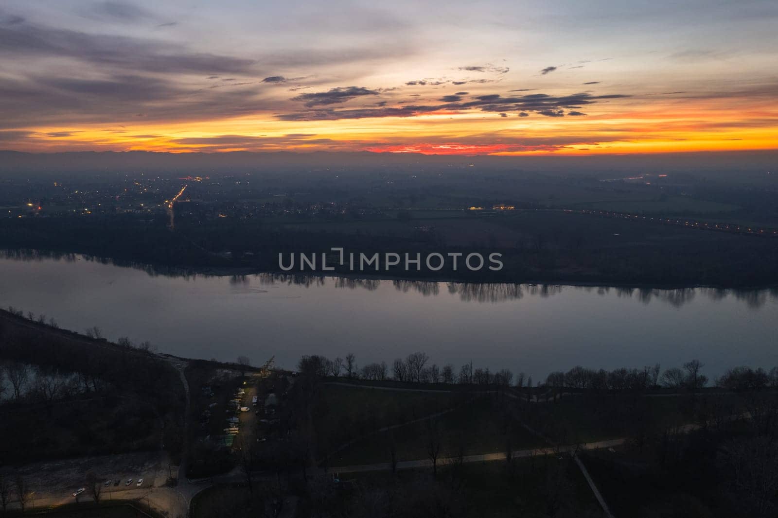 Cremona, Italy - January 2023 Sunset in plain near the city, Po bridge connecting Emilia Romagna and Lombardy