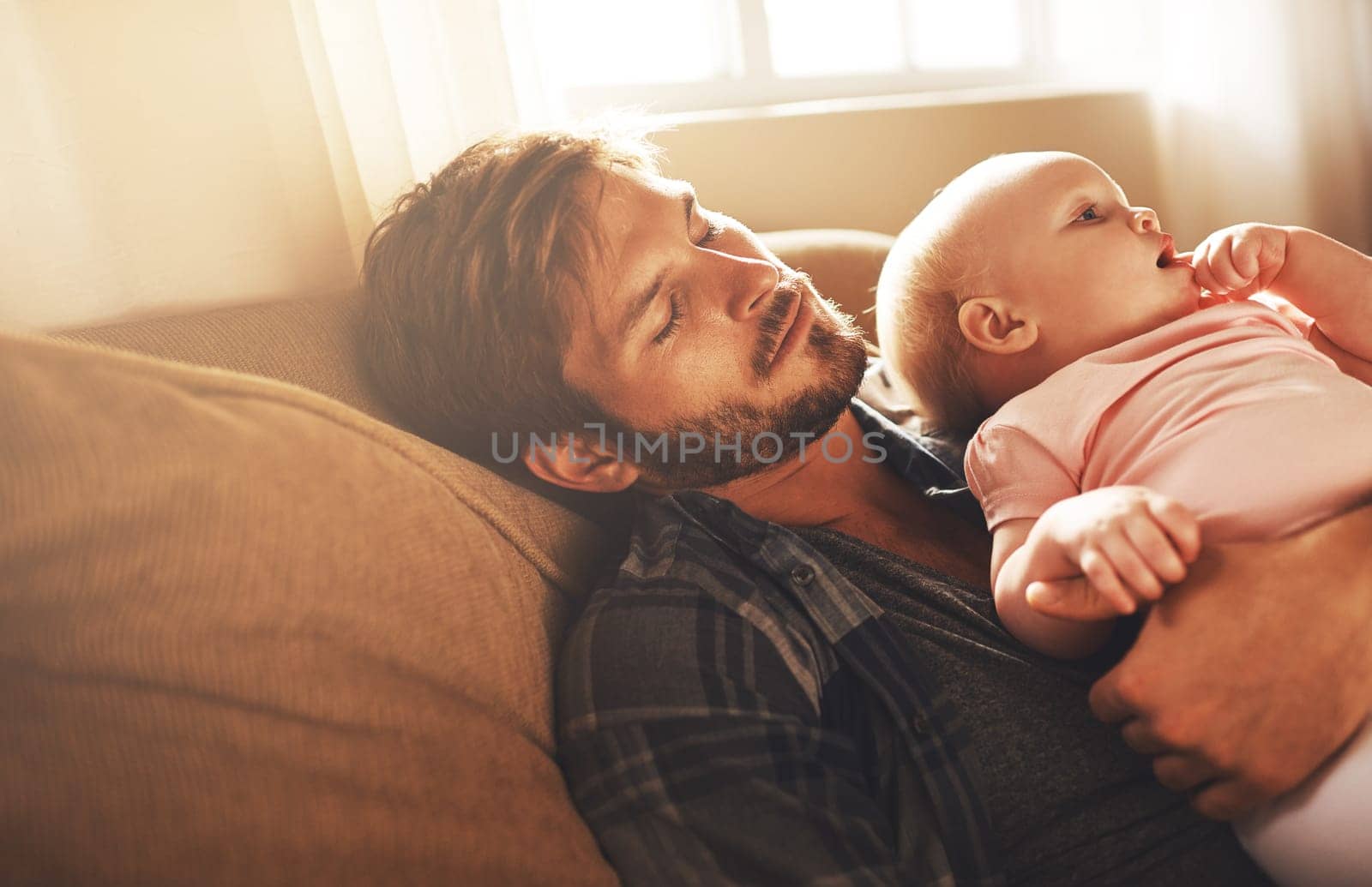 Whos putting who down to sleep. a young father and his baby daughter sleeping in the living room