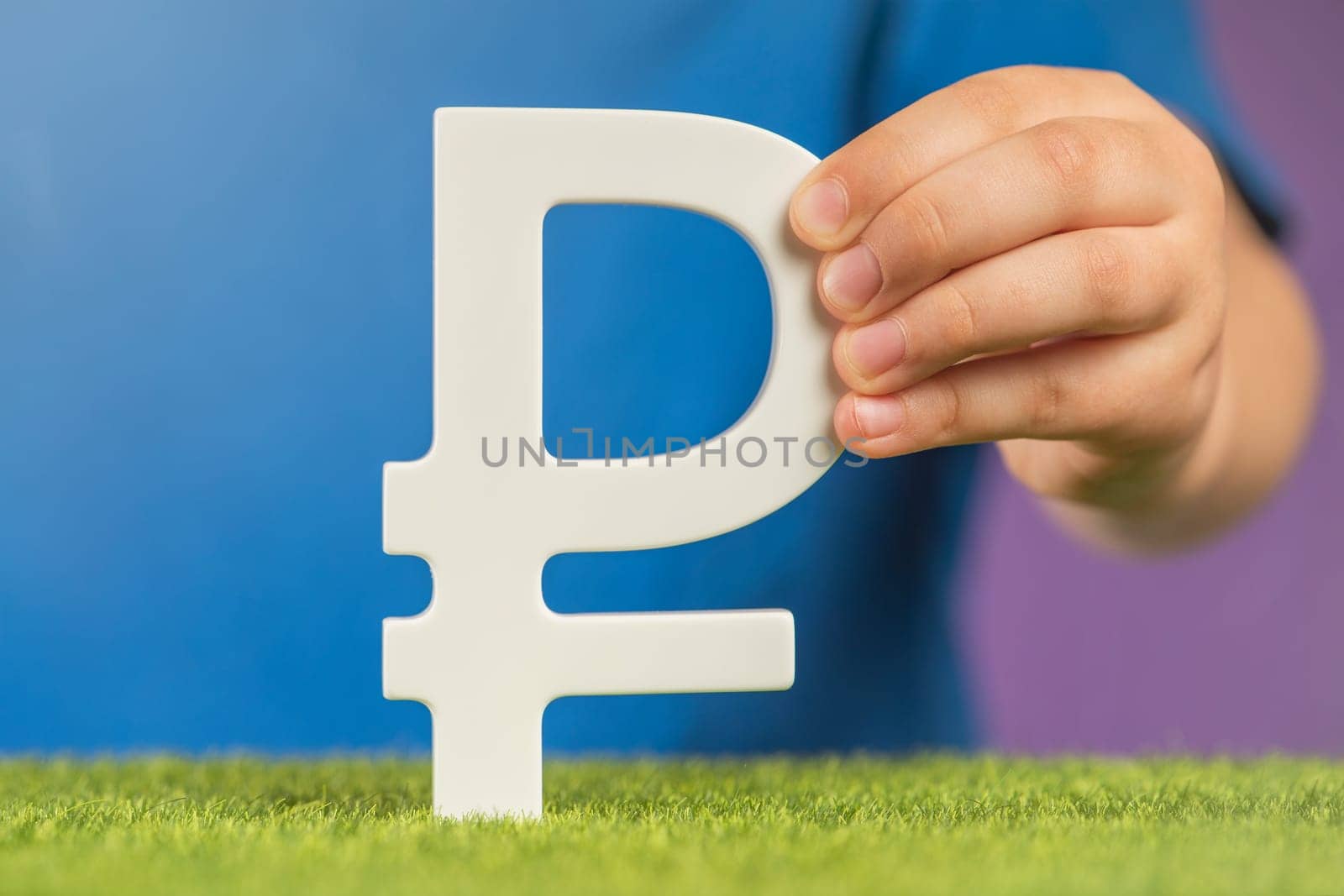 Ruble symbol in hands on a purple background. The concept of the growth or fall of the value of the ruble in the economy. Banner on financial topics. Recession and crisis in Russia. High quality photo