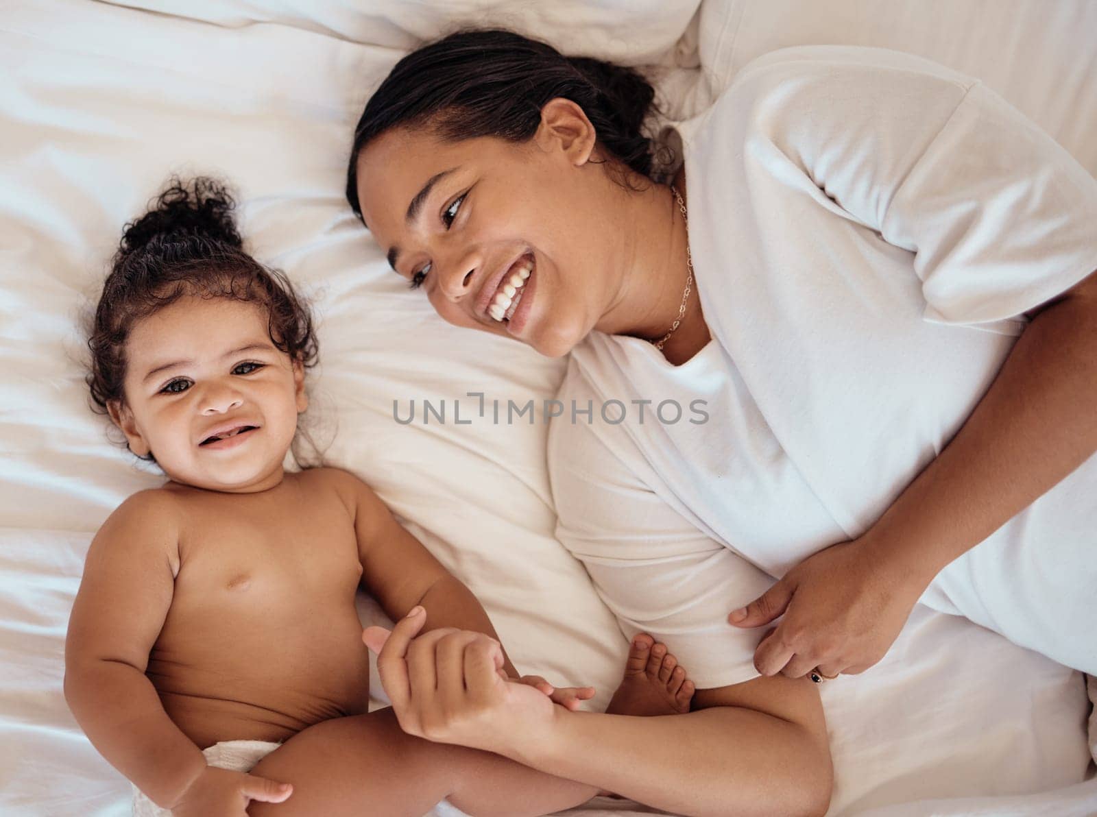 Top view, mama and baby with smile, on bed and happy together for bonding, childhood and loving in home. Love, mom or toddler in bedroom, happiness or positive for wellness, tenderness and motherhood.