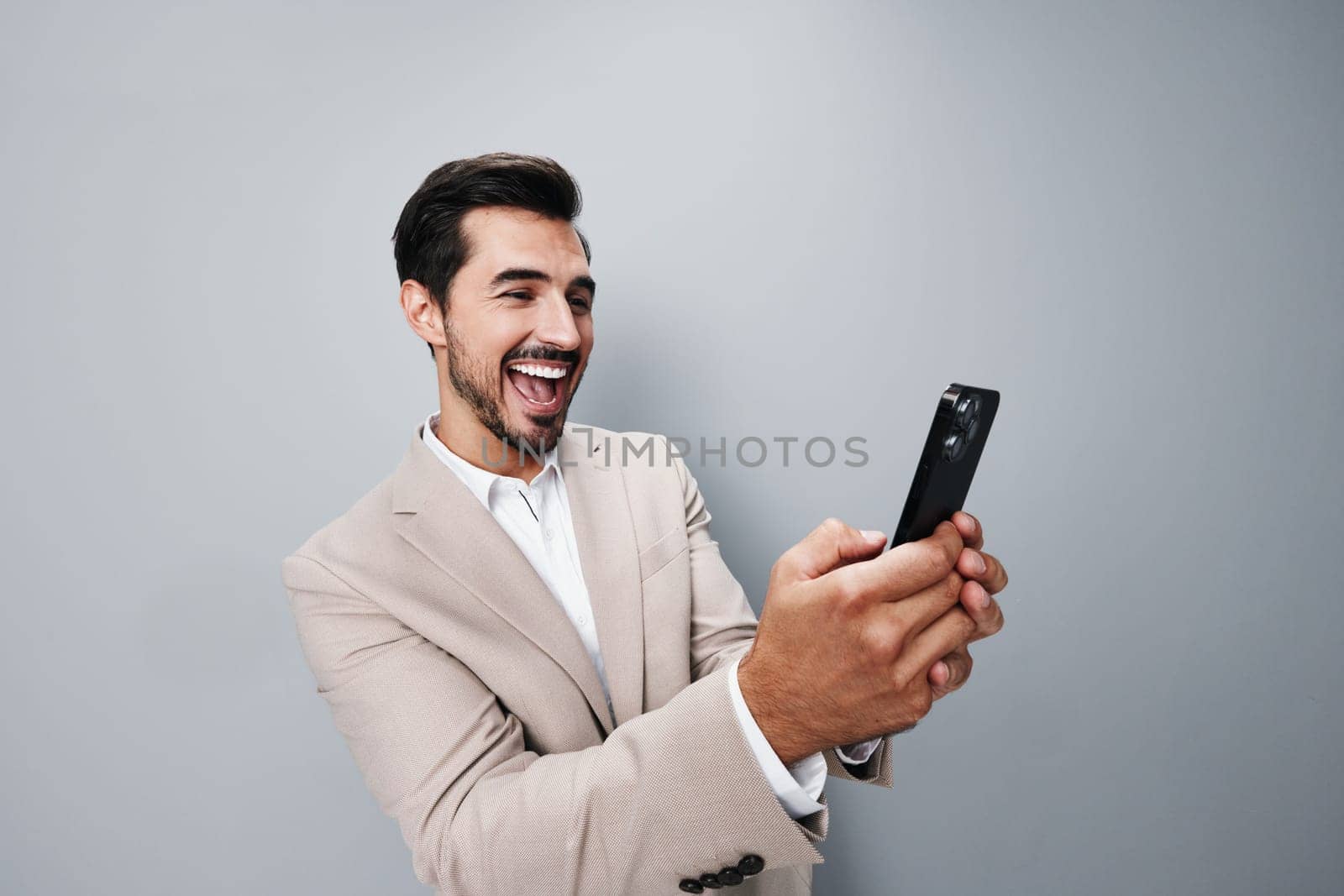 man studio phone suit portrait blogger call entrepreneur happy corporate success cellphone hold smile adult male business smartphone selfies confident beige