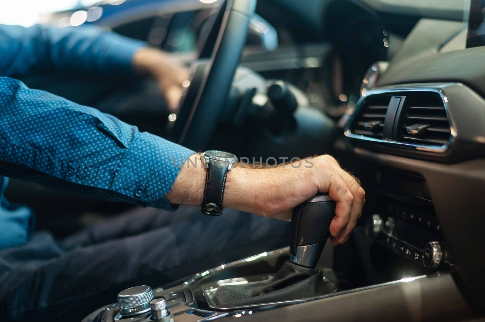 Close-up of a man's hand while shifting the automatic transmission of a car