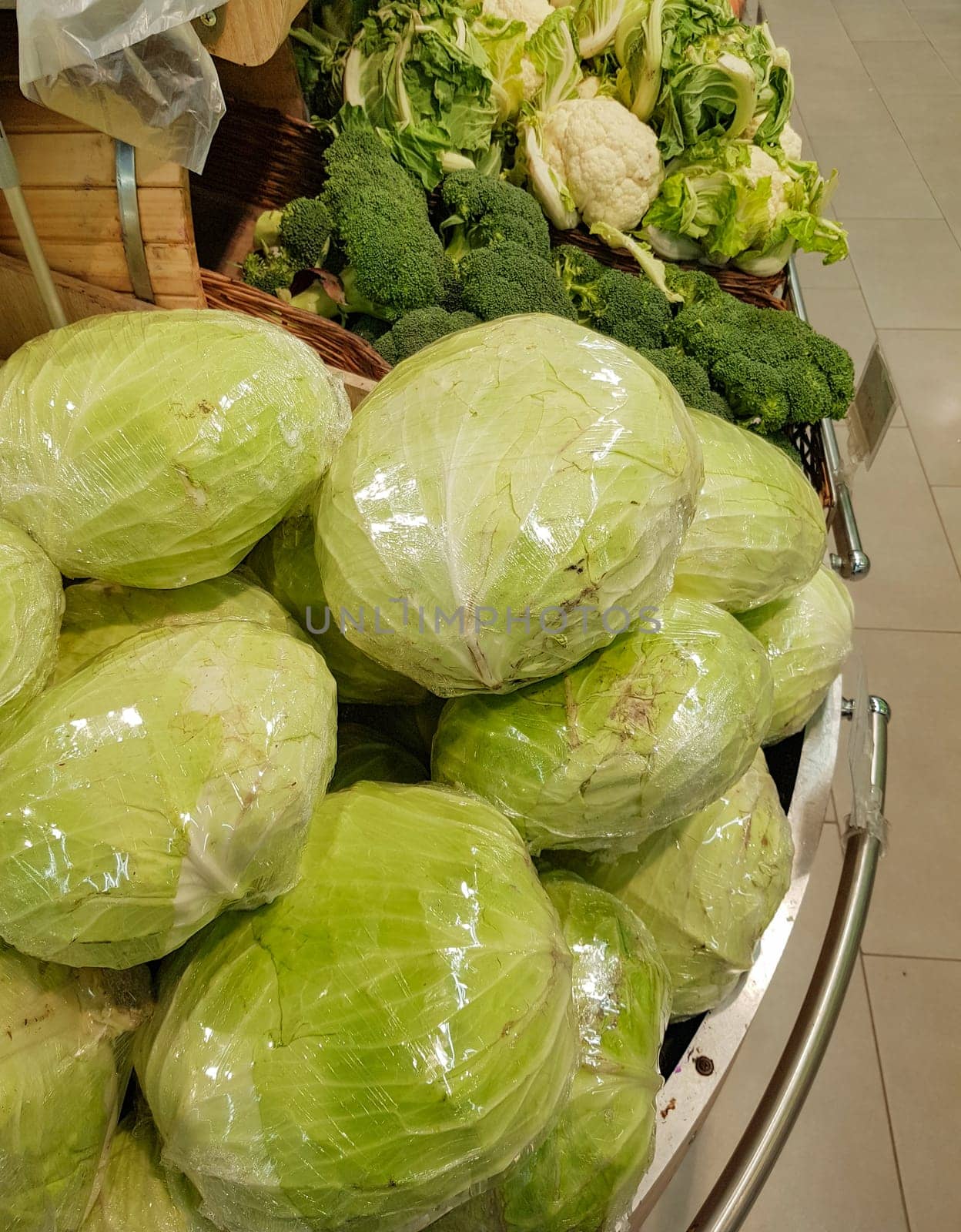 A large pile of fresh white cabbage on the counter in a vegetable supermarket or at the market by claire_lucia