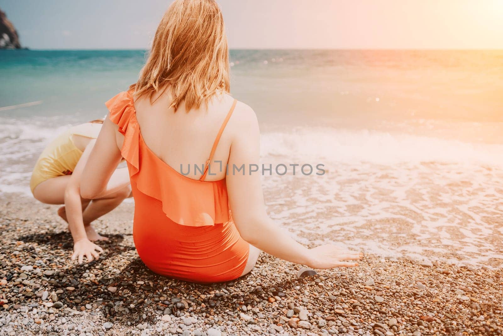 Happy loving family mother and daughter having fun together on the beach. Mum playing with her kid in holiday vacation next to the ocean - Family lifestyle and love concept by panophotograph