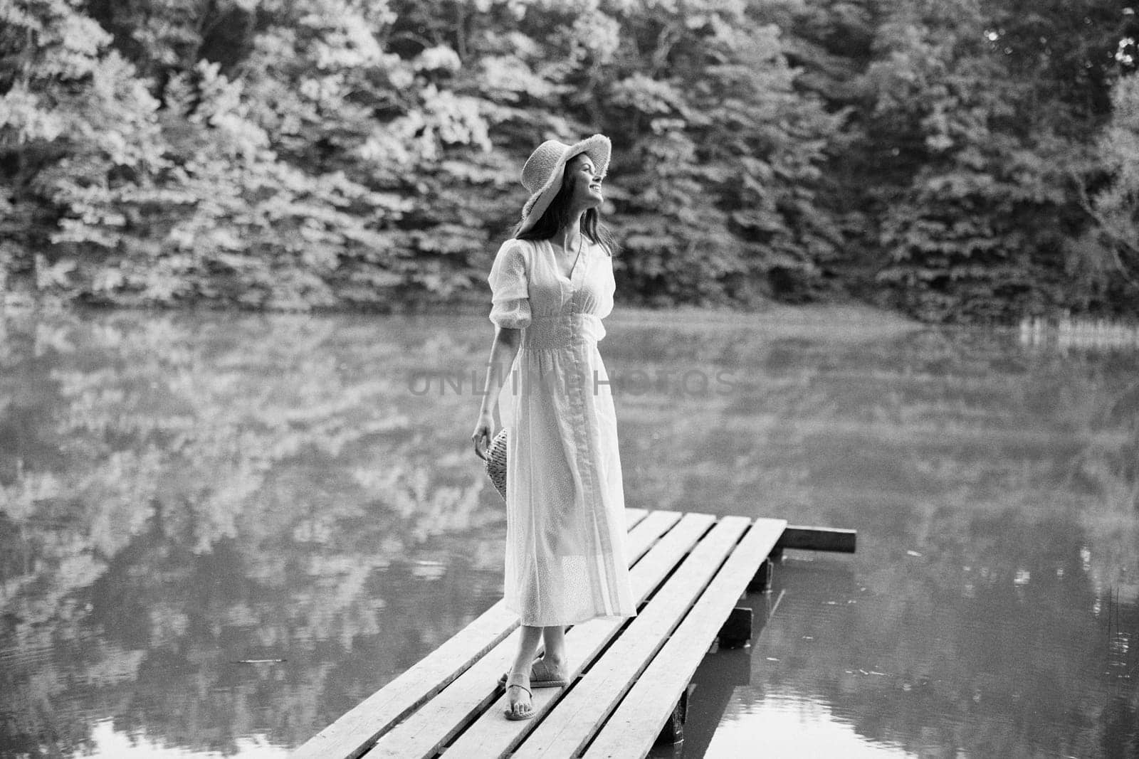 monochrome photo of a woman resting on a lake in the countryside in a long summer dress. High quality photo