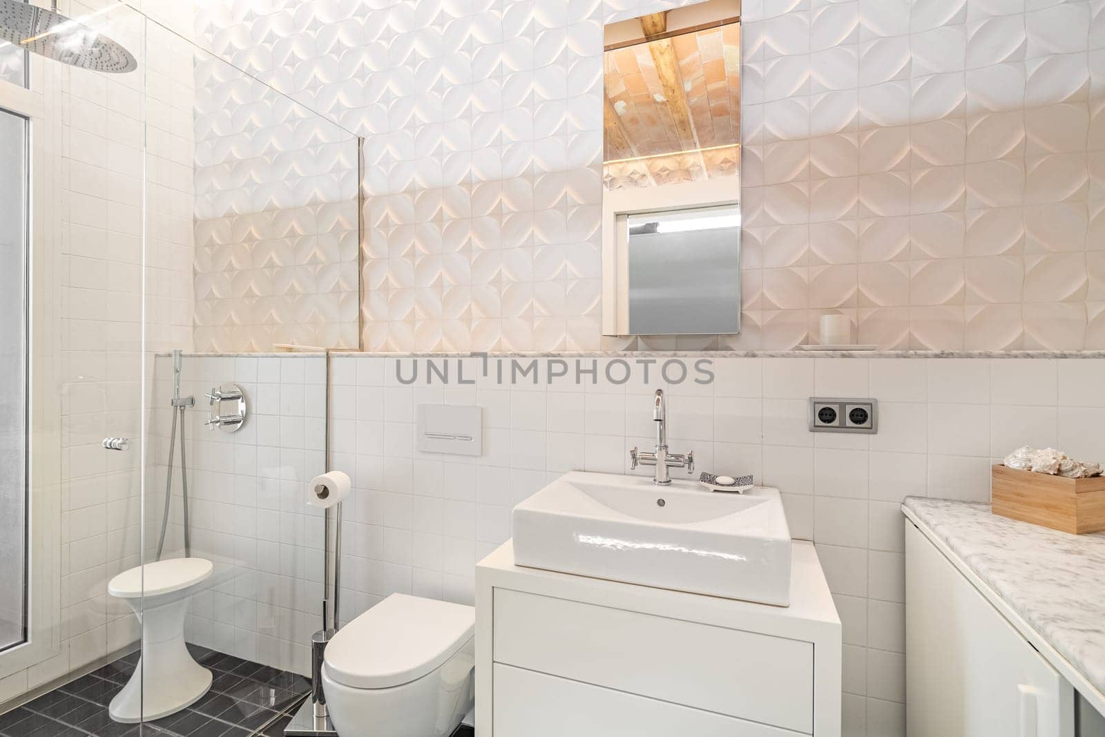 Modern refurbished tiled bathroom with shower zone, toilet, white sink and mirror