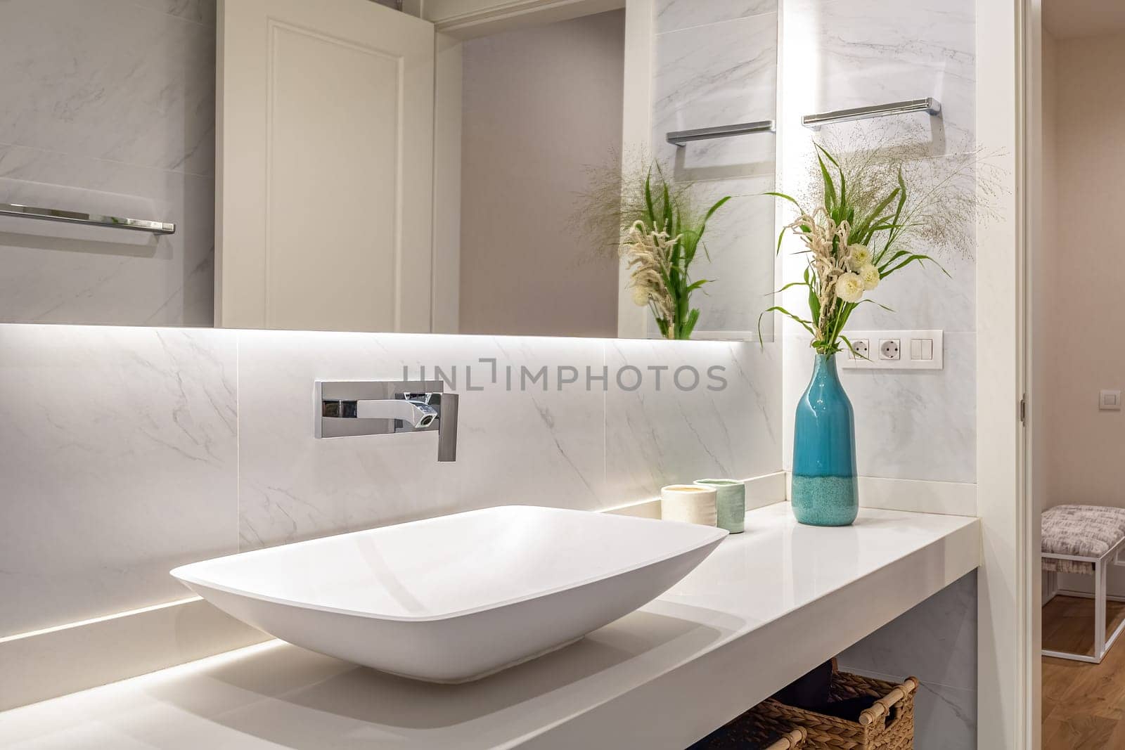 Interior design of a luxury bathroom and flowers in blue vase