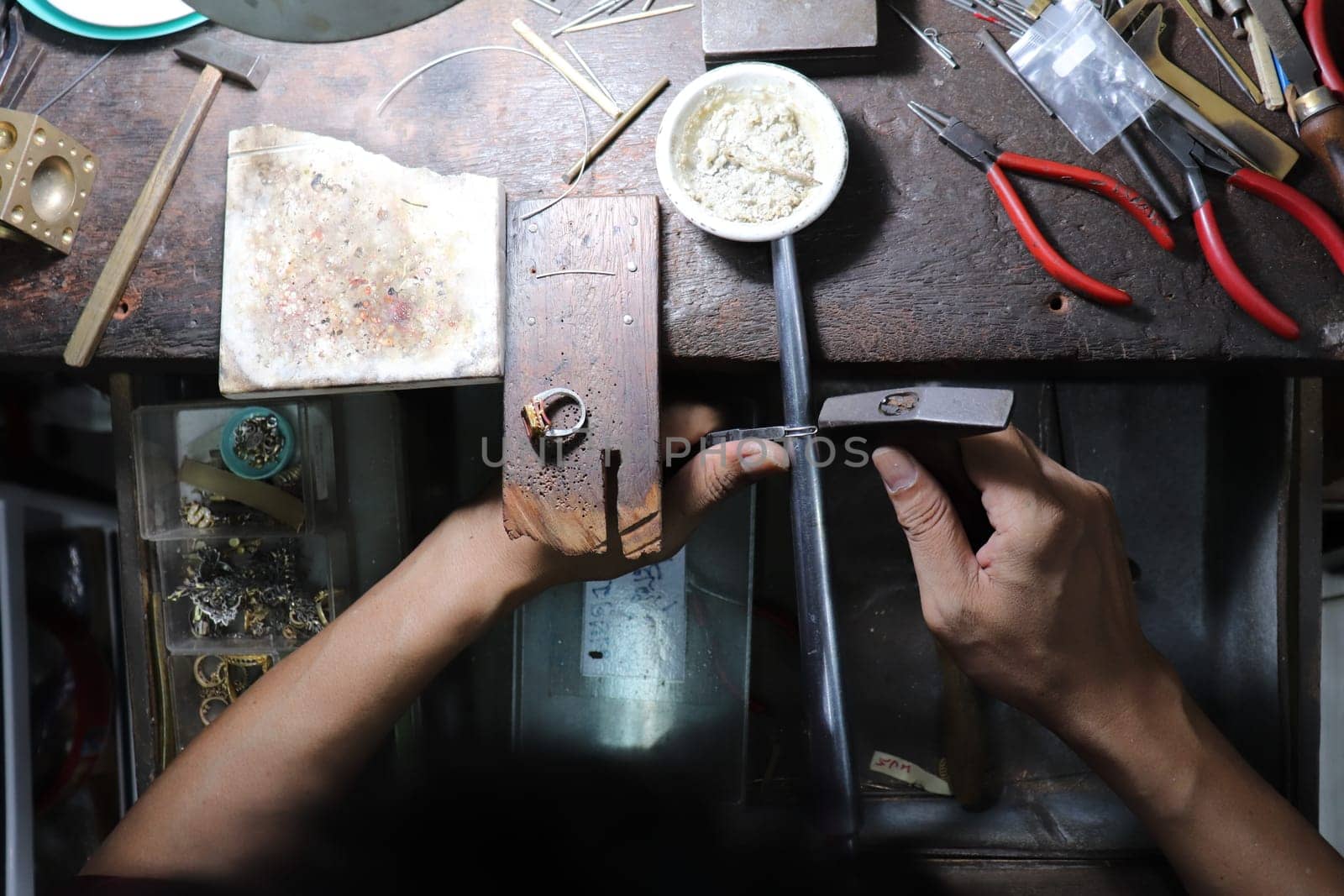 Old wood table for goldsmith with gold ring. Jeweler in Asia. Ancient and handmade jewelry work