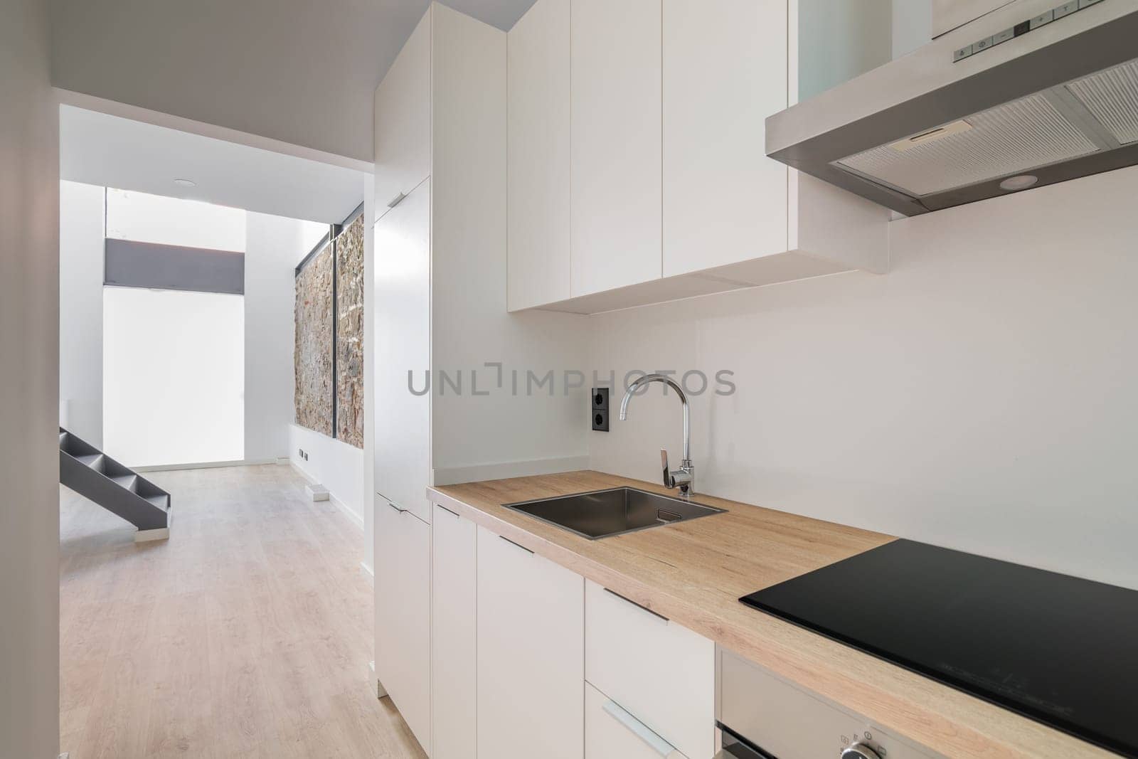 New kitchen with oven, stove and extractor. Interior with white cabinets and wooden counter top. by apavlin