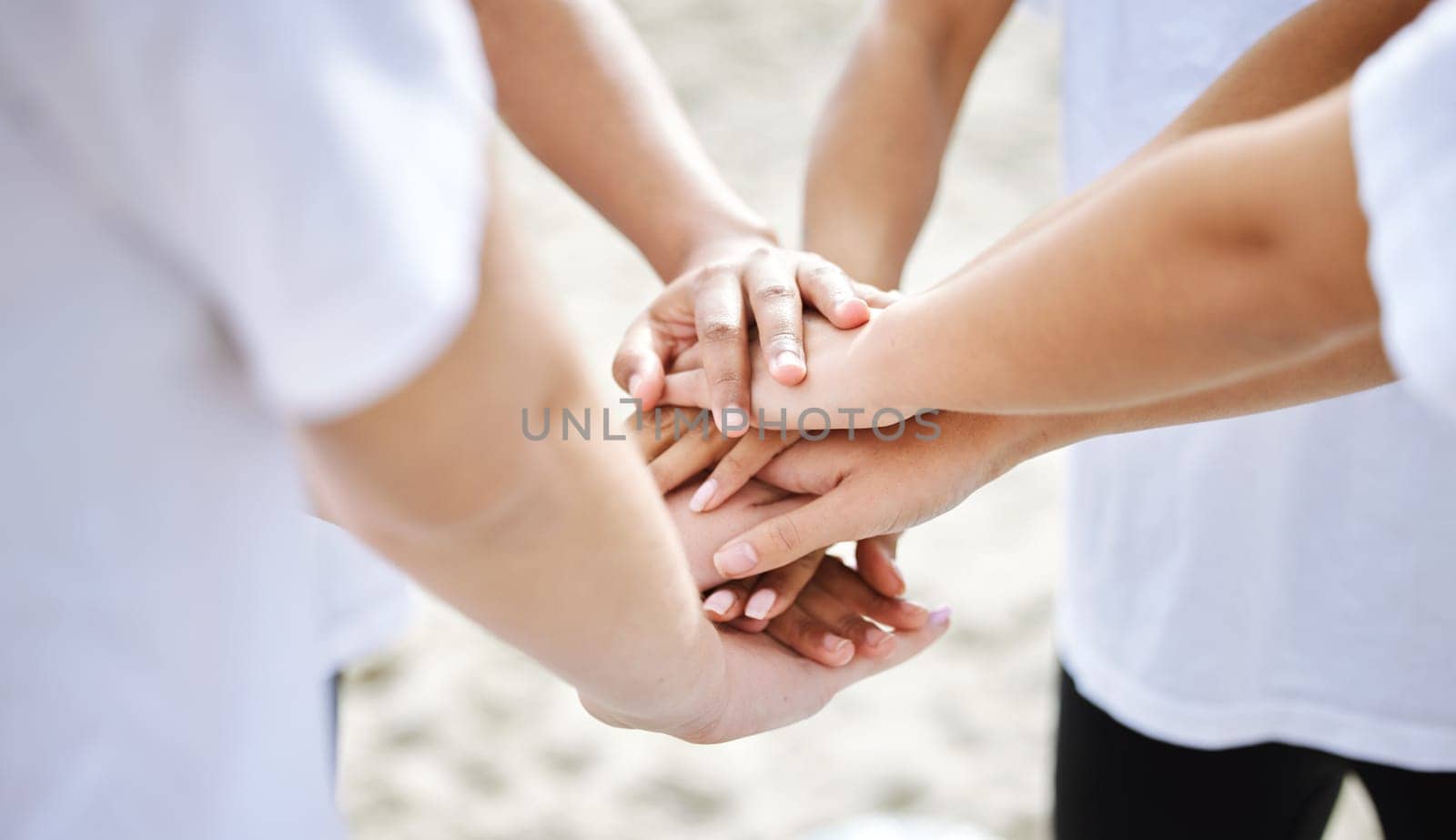 Hands together, teamwork and collaboration of people for sustainability or eco friendly at beach. Earth day, volunteer and group of men and women huddle for community service, support or charity