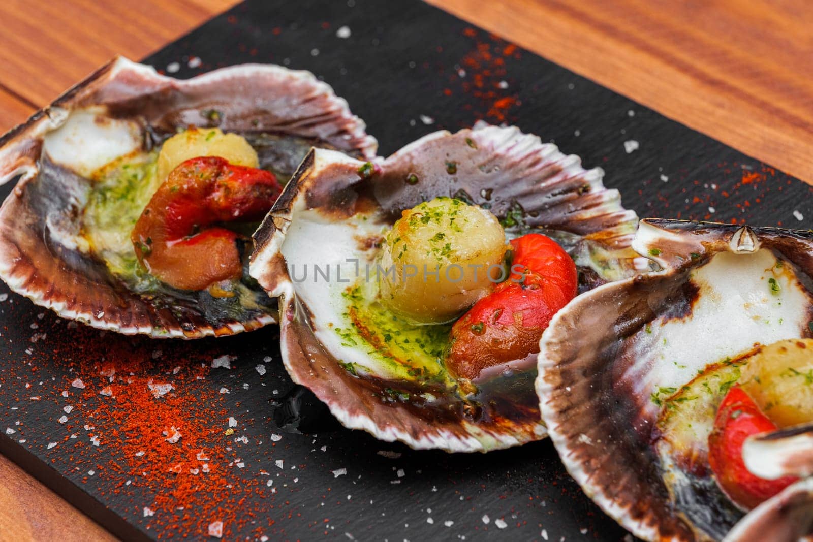 Cooked scallops on blackstone slate plate with species. Variety of Mediterranean seafood. by apavlin