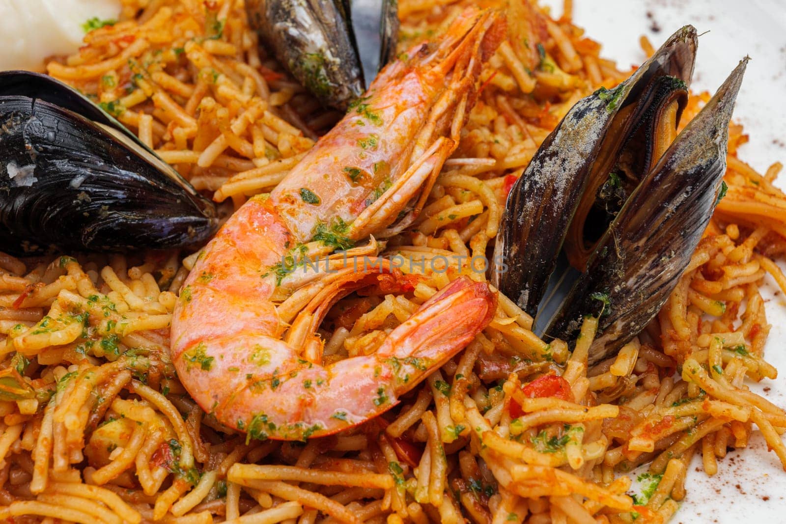 Noodles with tomato sauce and seafood, mussels and shrimps on white plate. by apavlin