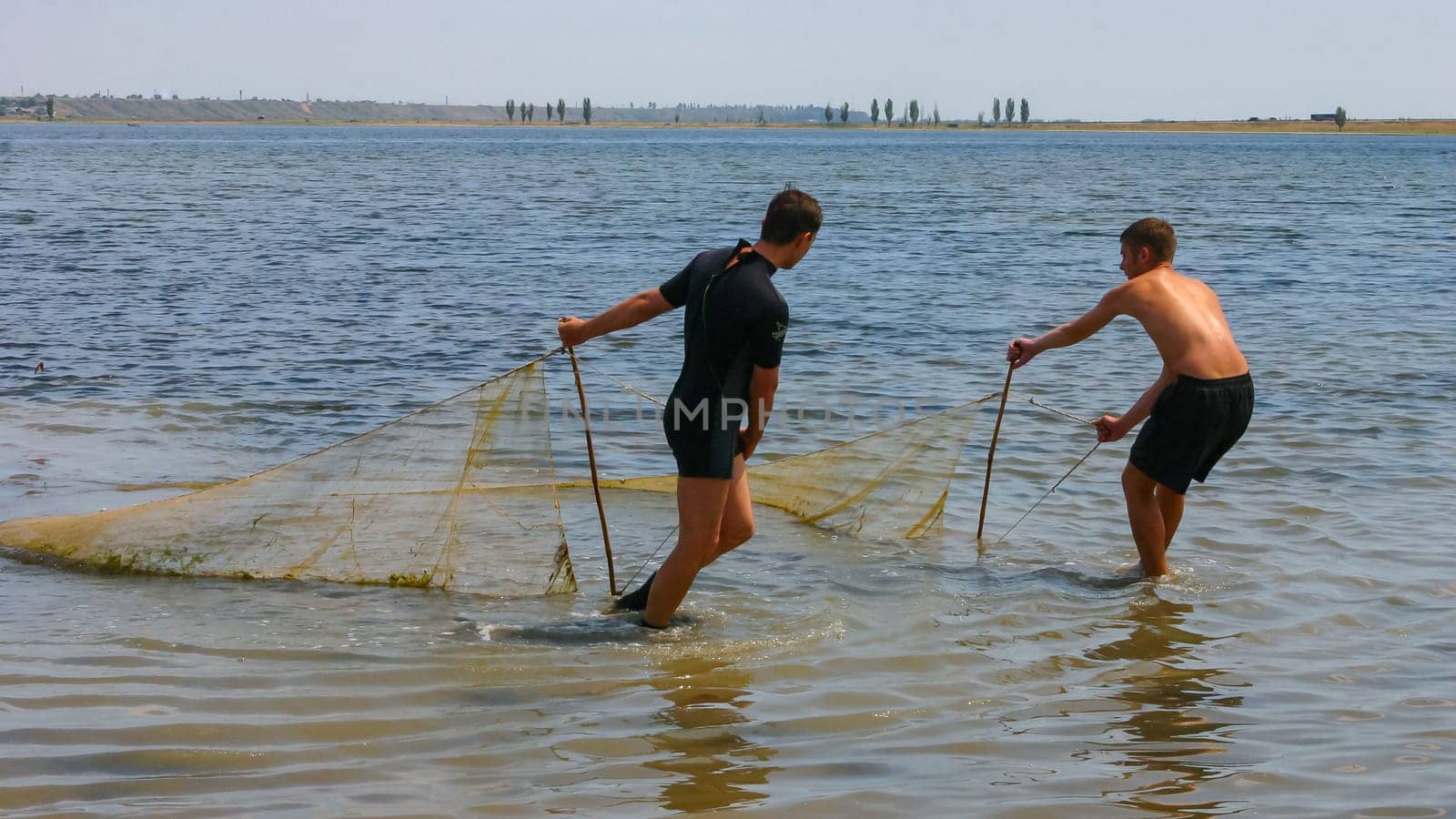 ODESSA, UKRAINE - JUNE 30, 2007: Fishermen catch fish with a net in a shallow pond, Tiligulsky Estuary Ukraine by Hydrobiolog