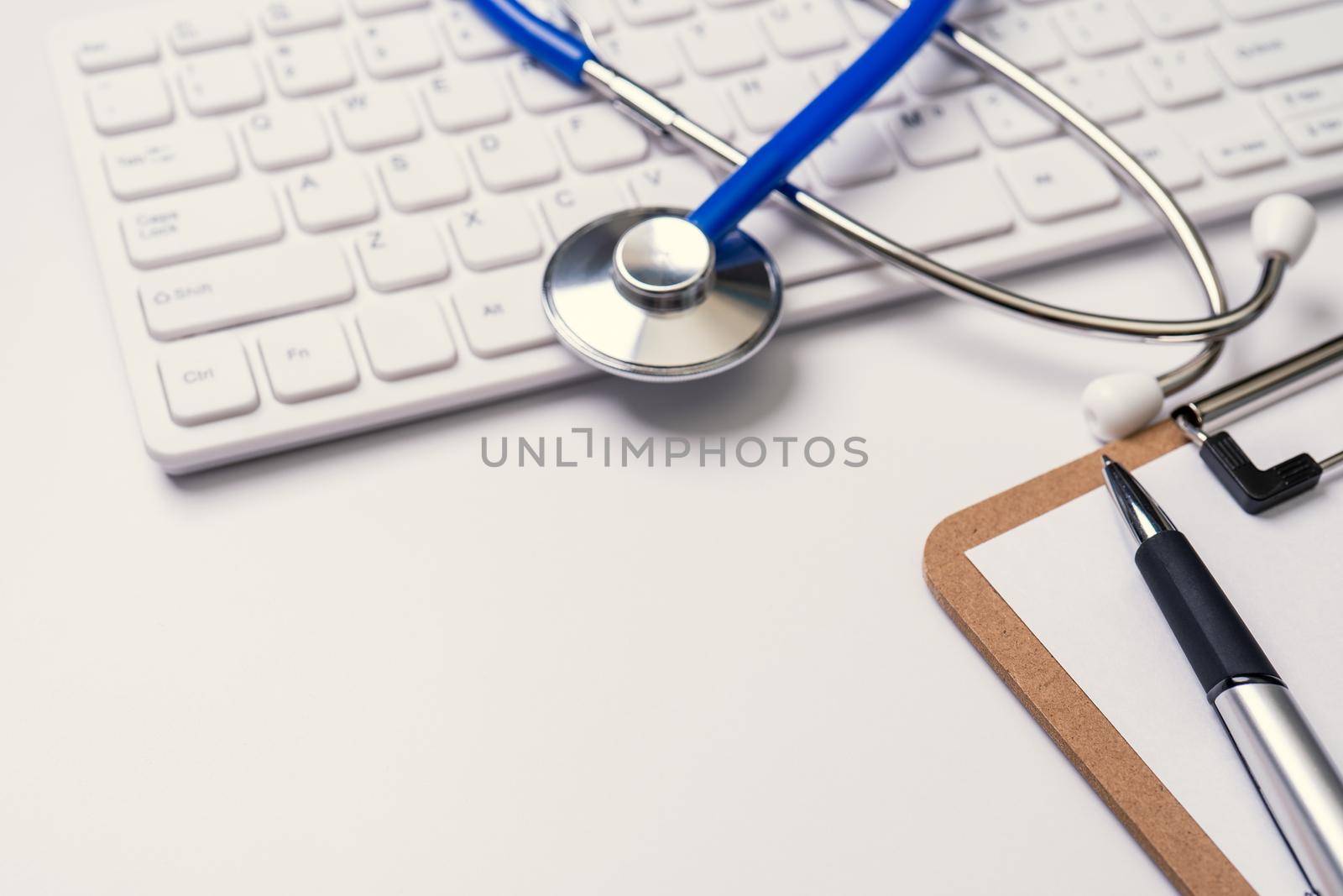 Medical Concept - Stethoscope on computer keyboard on white background. Physician long term care treatment. Close up, macro, copy space