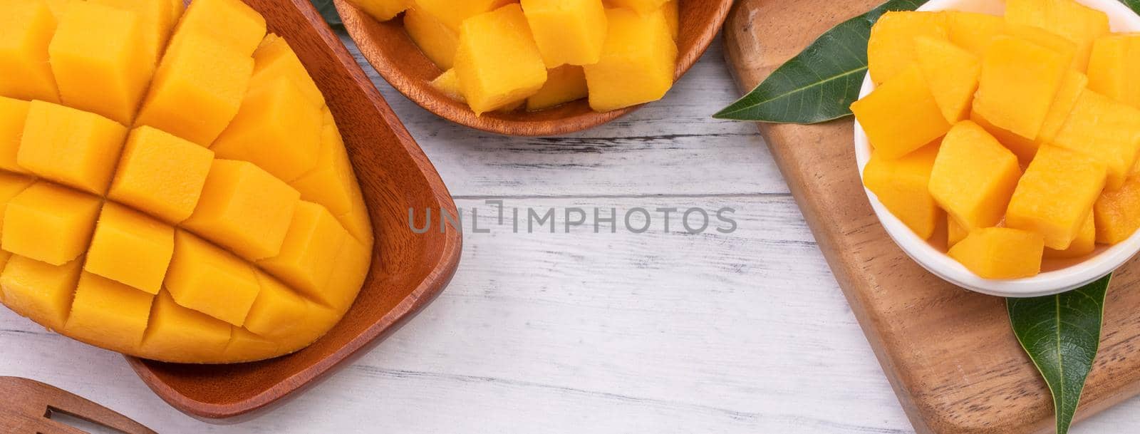 Fresh chopped mango on a tray and bright rustic wooden background. Tropical summer fruit design concept, close up, macro, copy space. by ROMIXIMAGE
