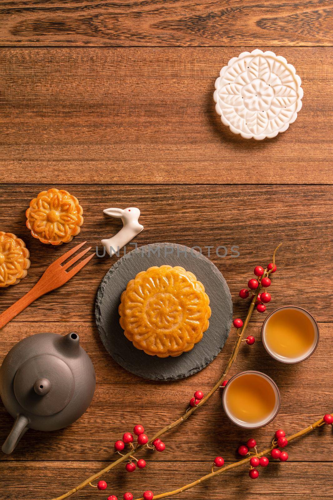 Creative Moon cake Mooncake table design - Chinese traditional pastry with tea cups on wooden background, Mid-Autumn Festival concept, top view, flat lay.