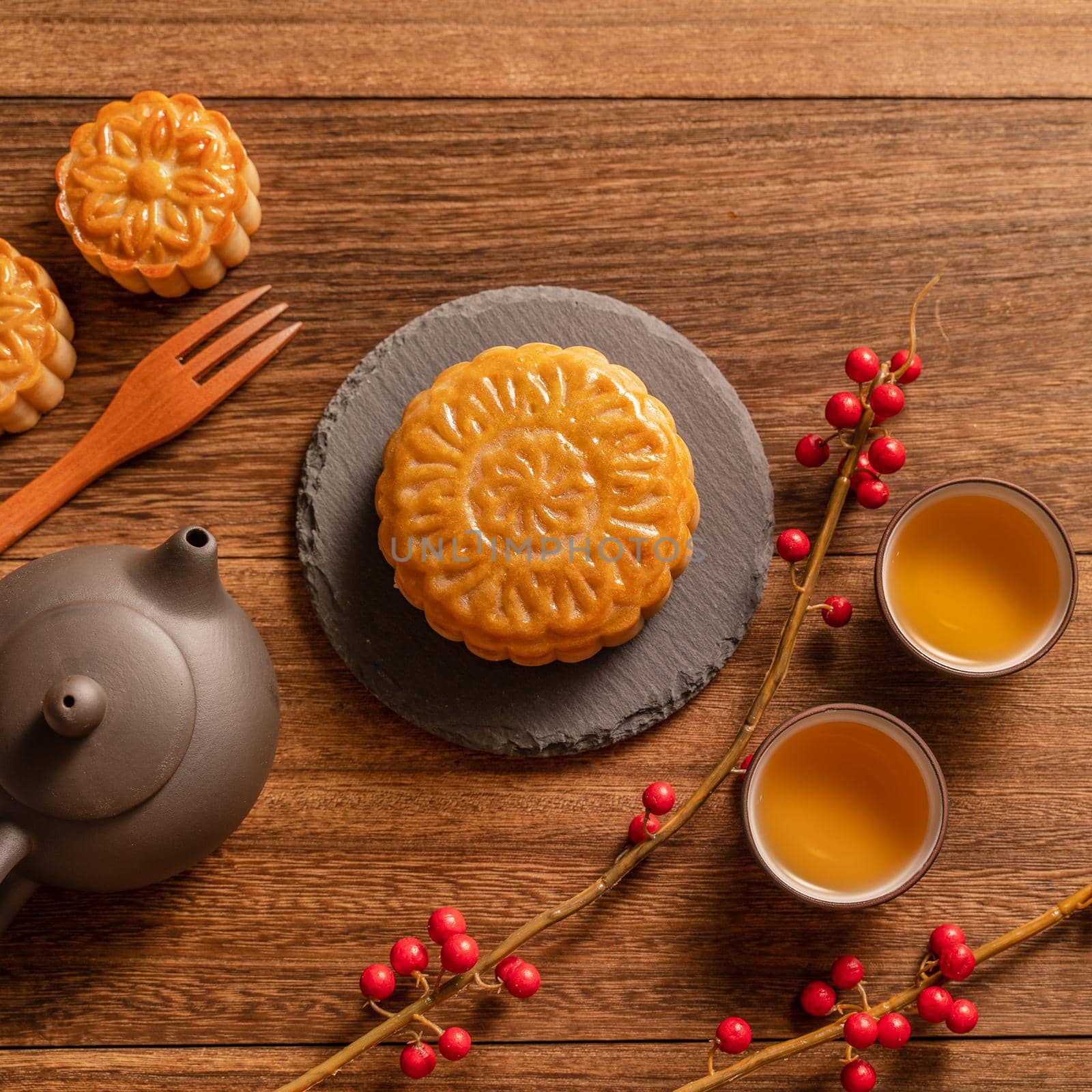 Moon cake Mooncake table setting - Chinese traditional pastry with tea cups on wooden background, Mid-Autumn Festival concept, top view, flat lay.