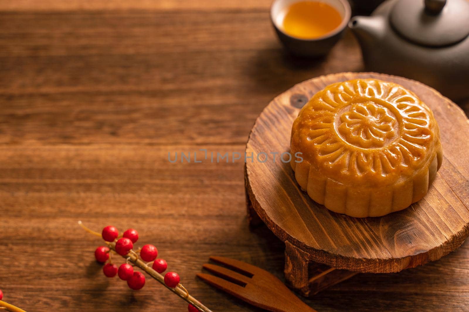 Moon cake Mooncake table setting - Round shaped Chinese traditional pastry with tea cups on wooden background, Mid-Autumn Festival concept, close up.