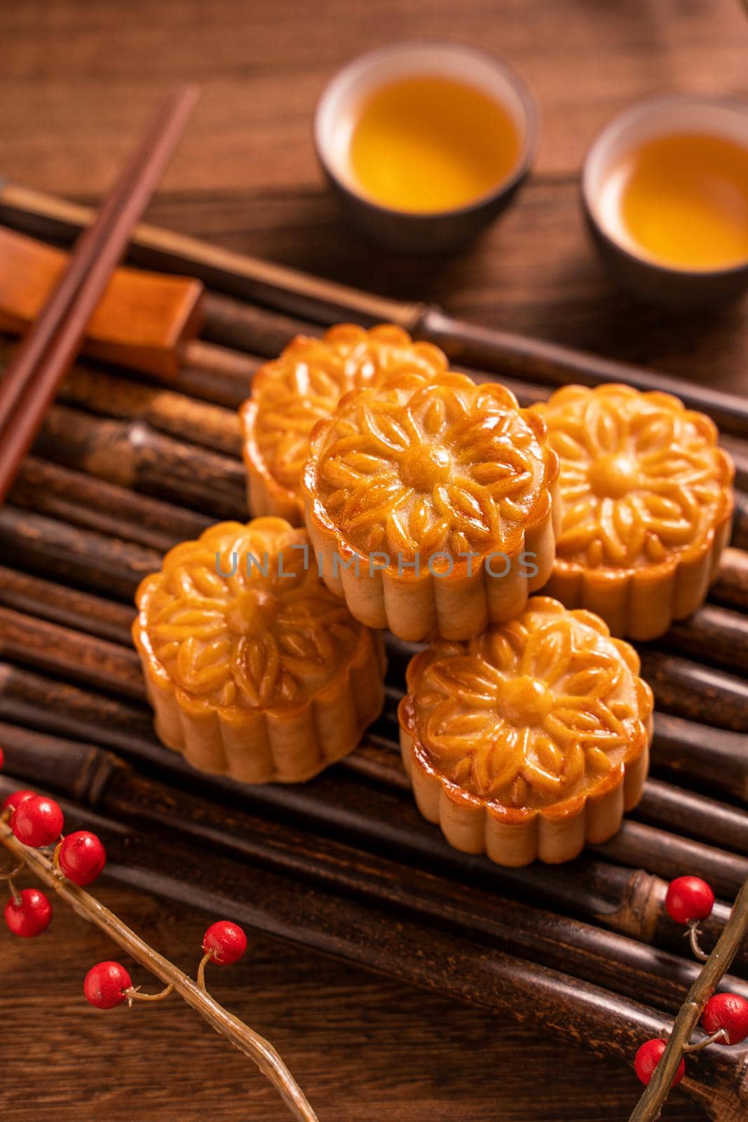 Chinese traditional pastry Moon cake Mooncake with tea cups on bamboo servingwarning tray on wooden background for Mid-Autumn Festival, close up.