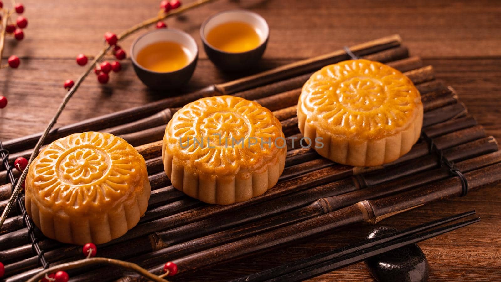 Chinese traditional pastry Moon cake Mooncake with tea cups on bamboo servingwarning tray on wooden background for Mid-Autumn Festival, close up.