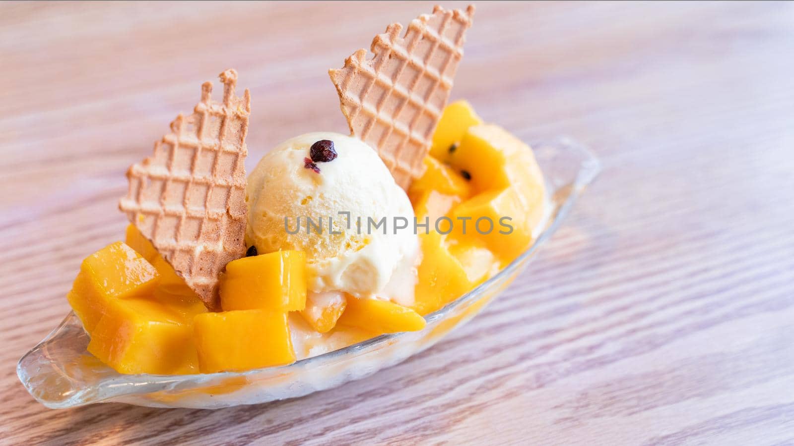 Fresh mango shaved ice with a scoop of ice cream and juice sauce in summer restaurant, lifestyle, popular food in Taiwan, close up.